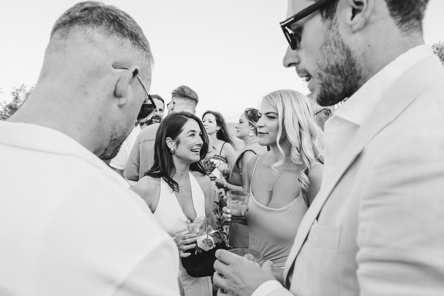 A sequence of black and white photos capturing intimate wedding moments during a sunny outdoor celebration.