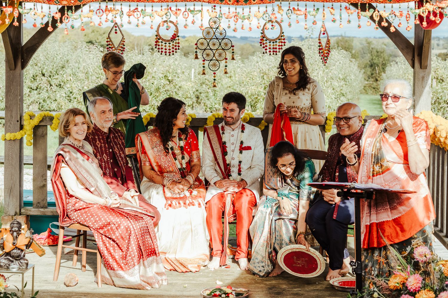 A festive cultural celebration with musicians and guests gathered under a decorated pavilion.