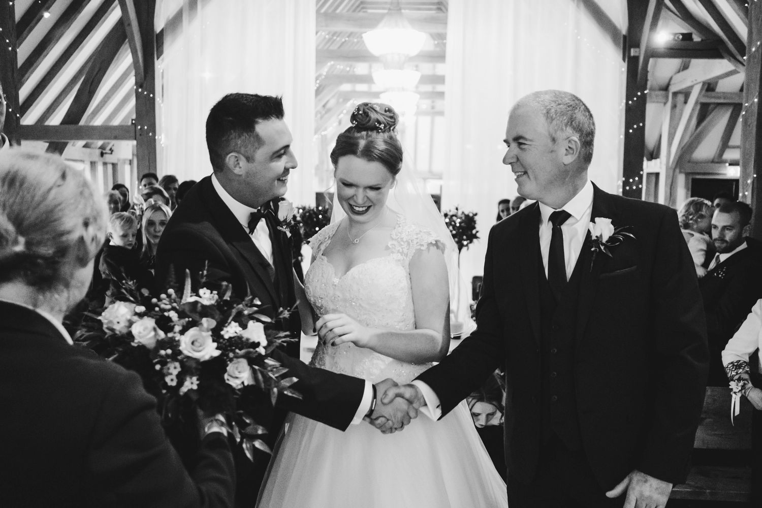 Wedding celebration in a traditional timber-frame barn with natural lighting.