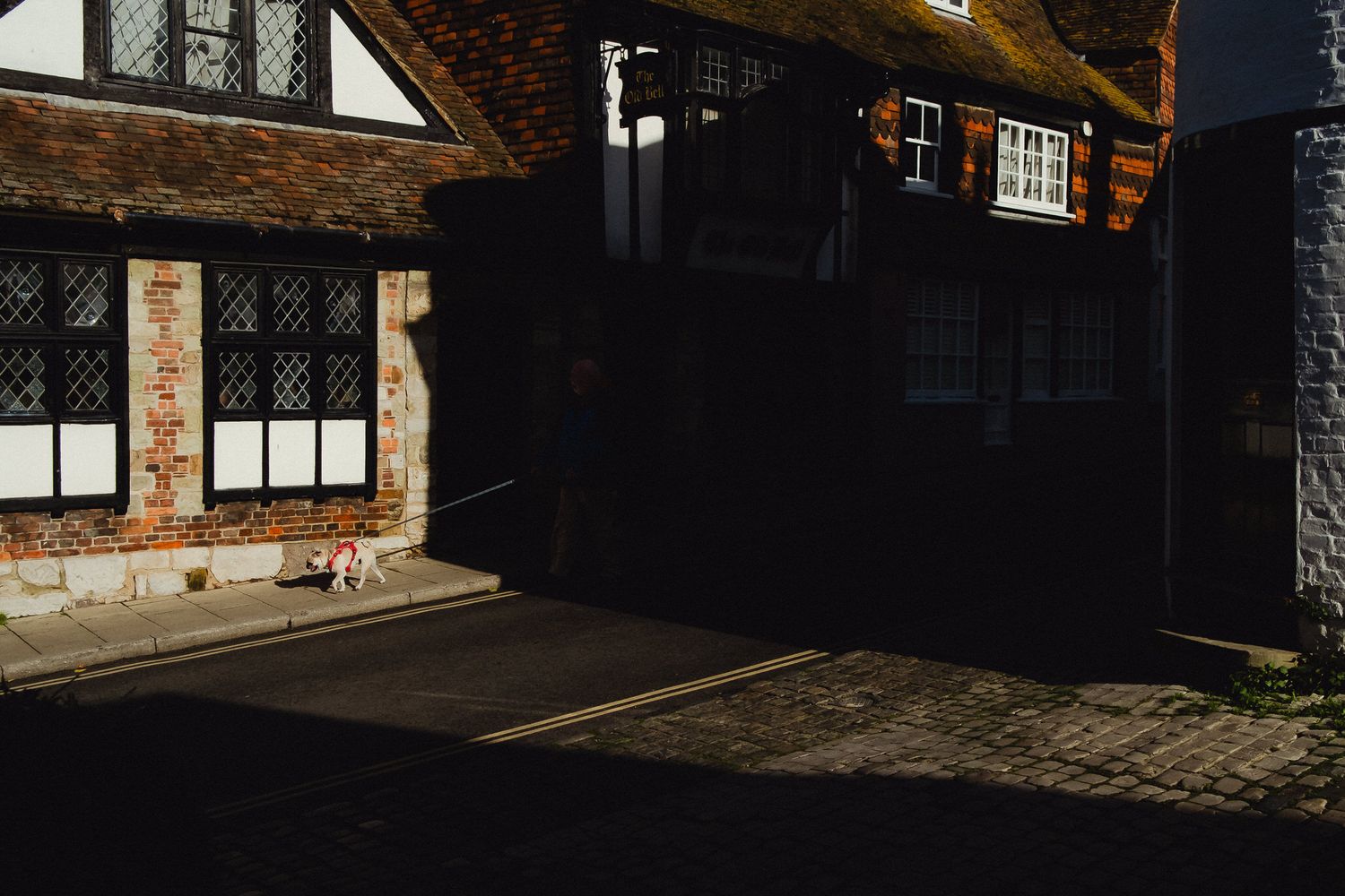 Vintage brick buildings and cobblestone streets line a historic alleyway in York, England.