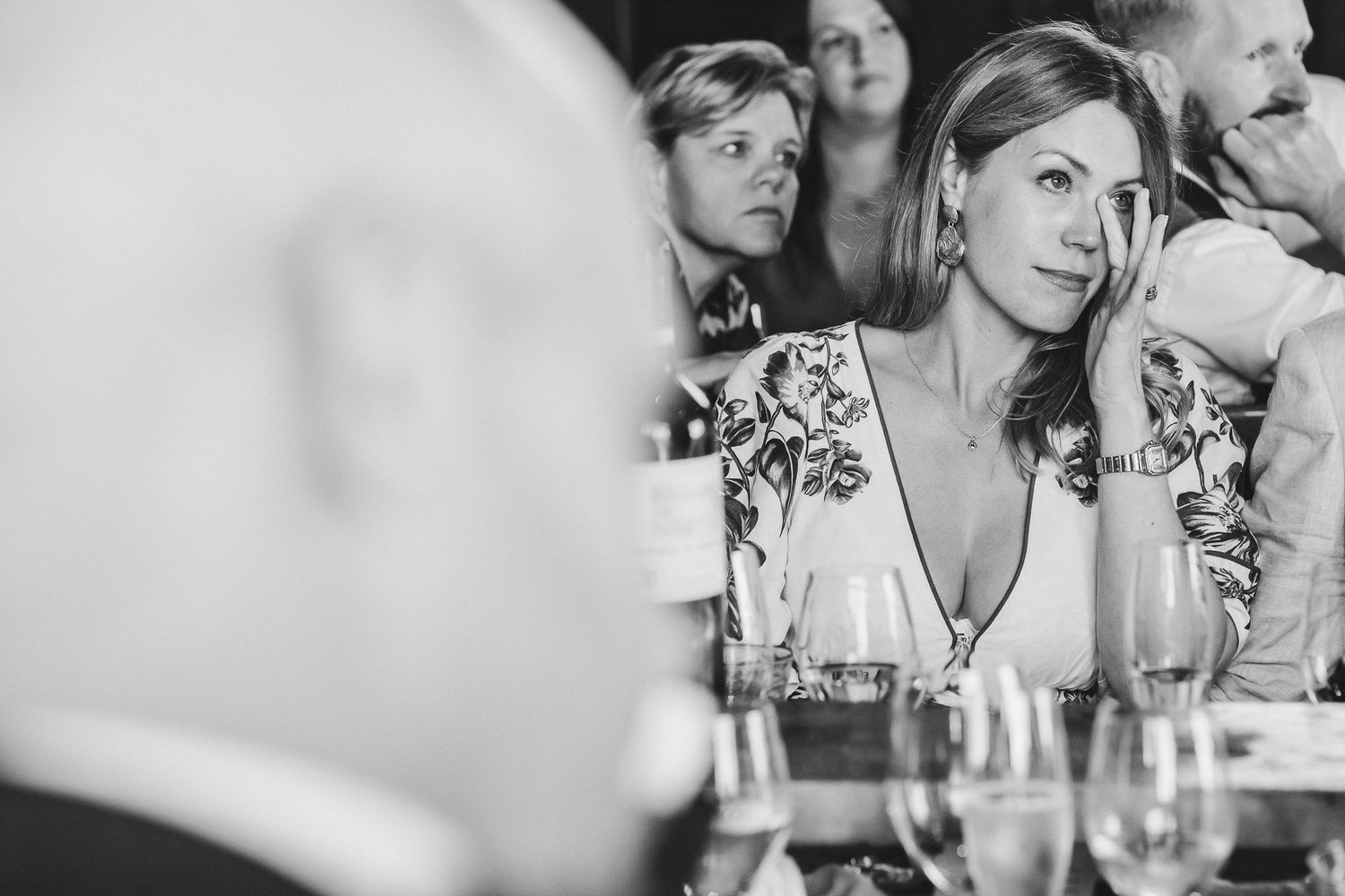 People seated at a dining table engaged in lively conversation and laughter at a social event.