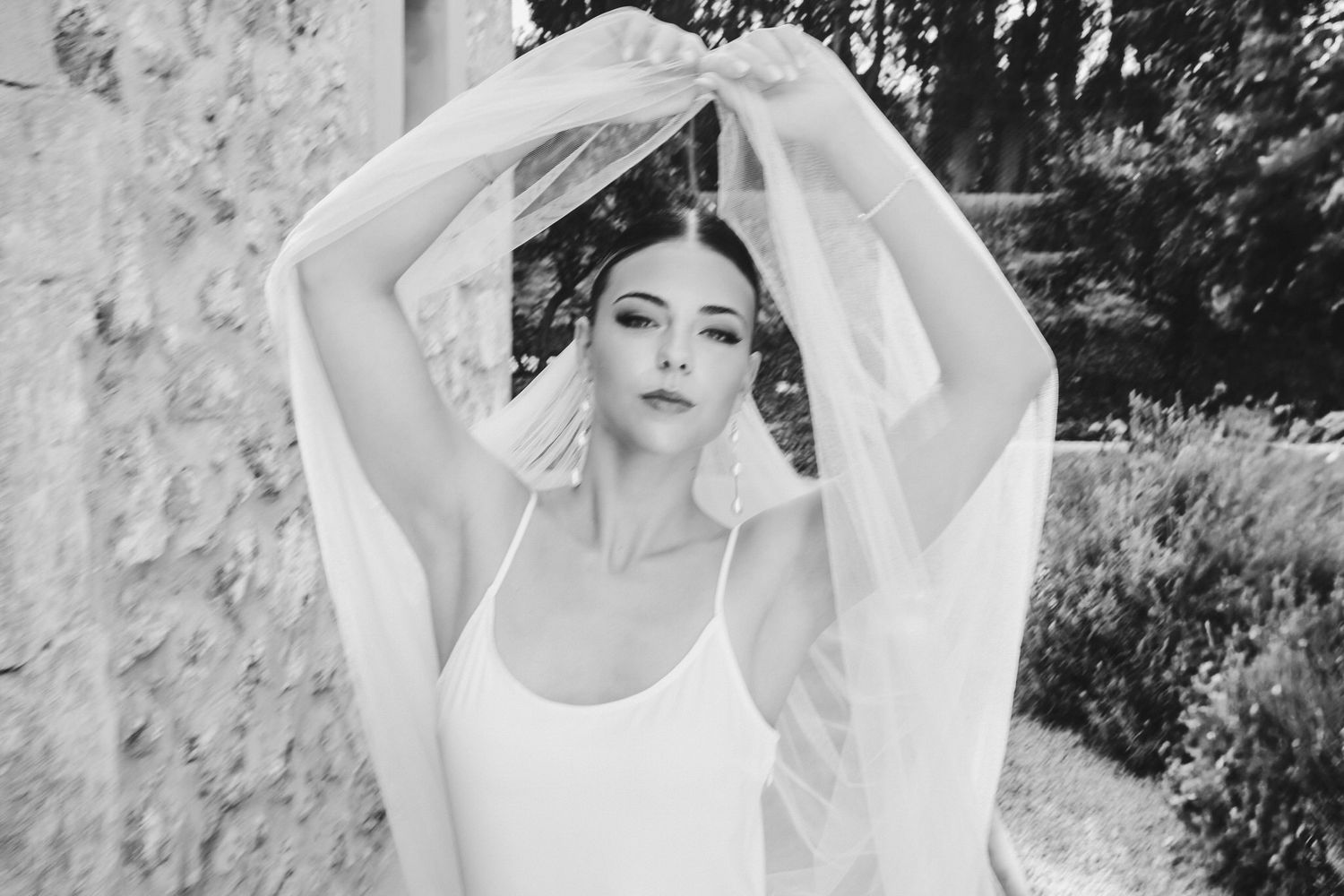 A black and white photo series shows a person in white clothing posing gracefully against a natural outdoor backdrop.