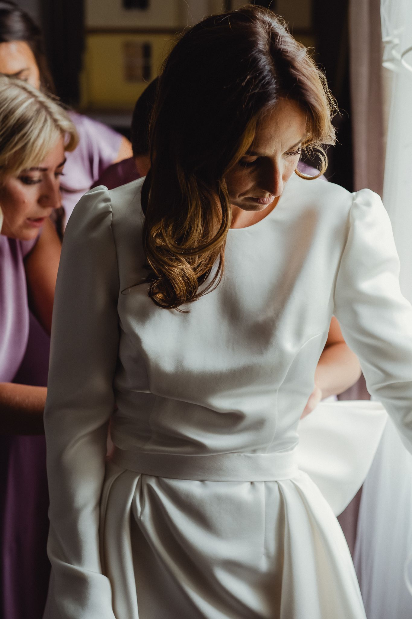 A series of images showing the back of a white wedding dress with elegant draping and gathered fabric details.