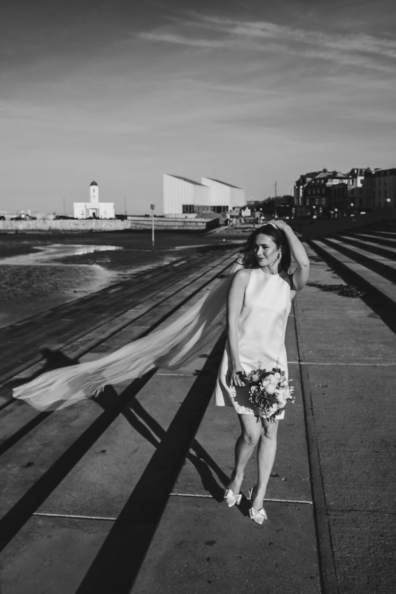 A sequence of black and white photos showing a figure in white moving across concrete steps casting long shadows.