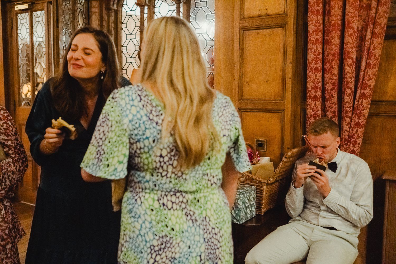 People gathered in an elegant indoor venue with ornate decor and wooden paneling during a celebration.