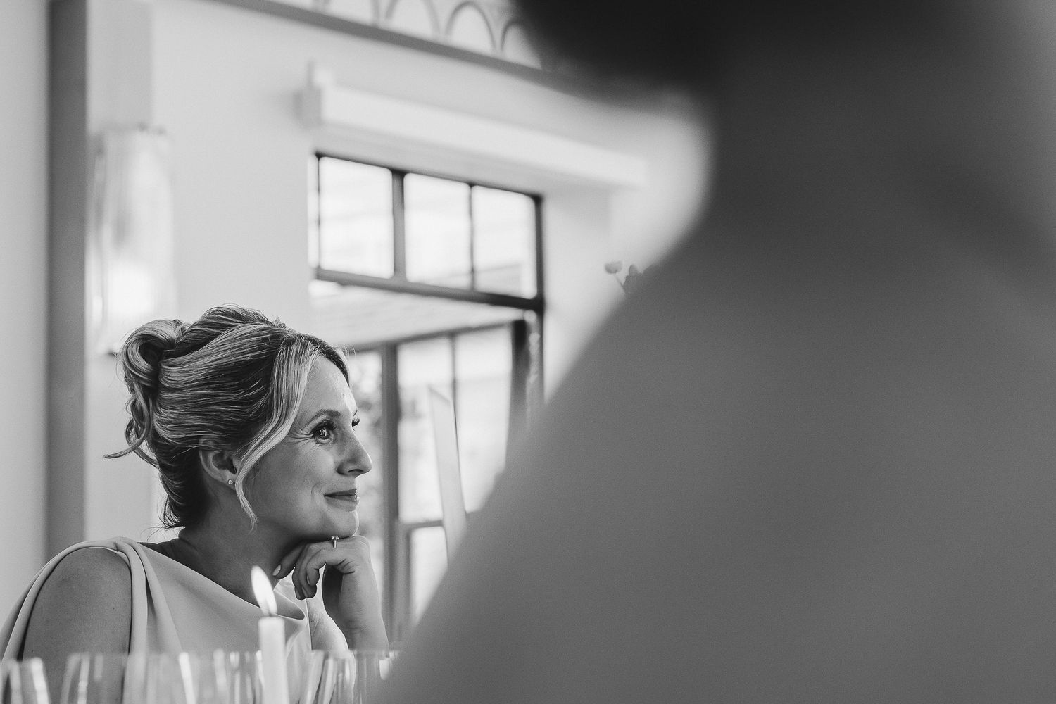 Black and white wedding photos showing bride and groom in romantic poses by window light.