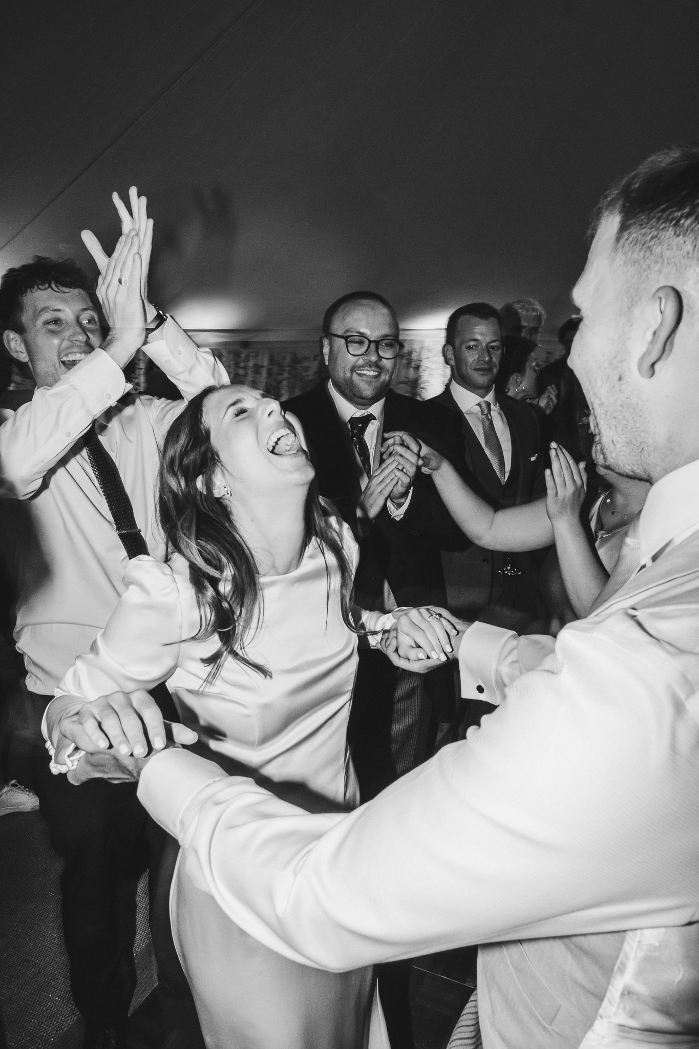 Black and white photos show energetic dancing and celebration at a lively wedding reception party.