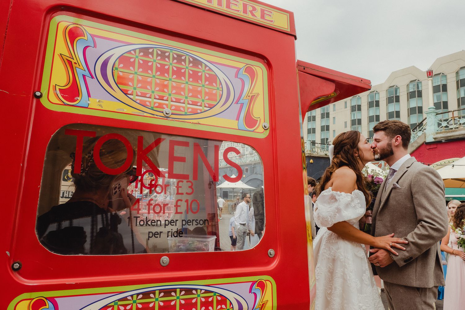 Red vintage-style token booth with ornate gold lettering and decorative elements on display at a public event.