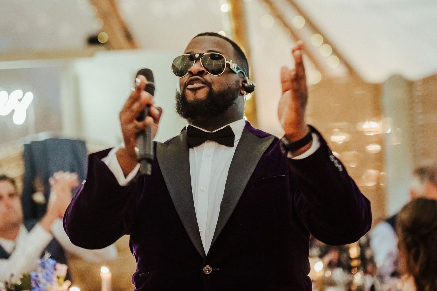 Wedding singer performs passionately in formal attire during reception celebration.
