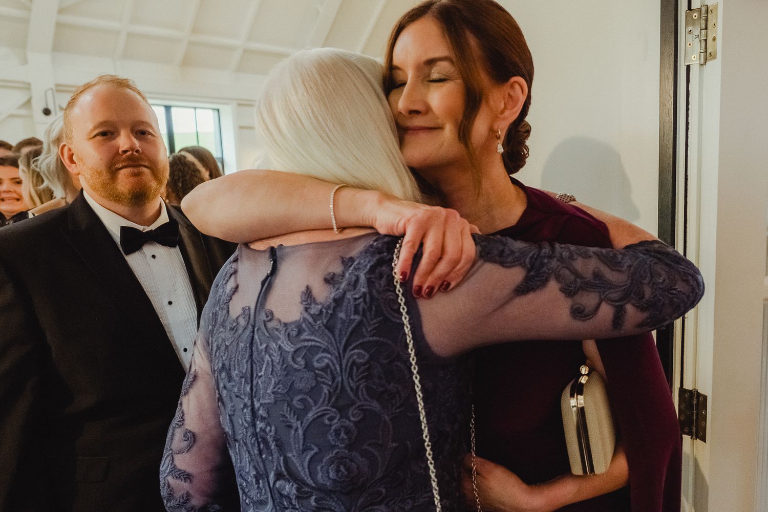 Wedding guests share joyful moments and laughter during an indoor celebration.