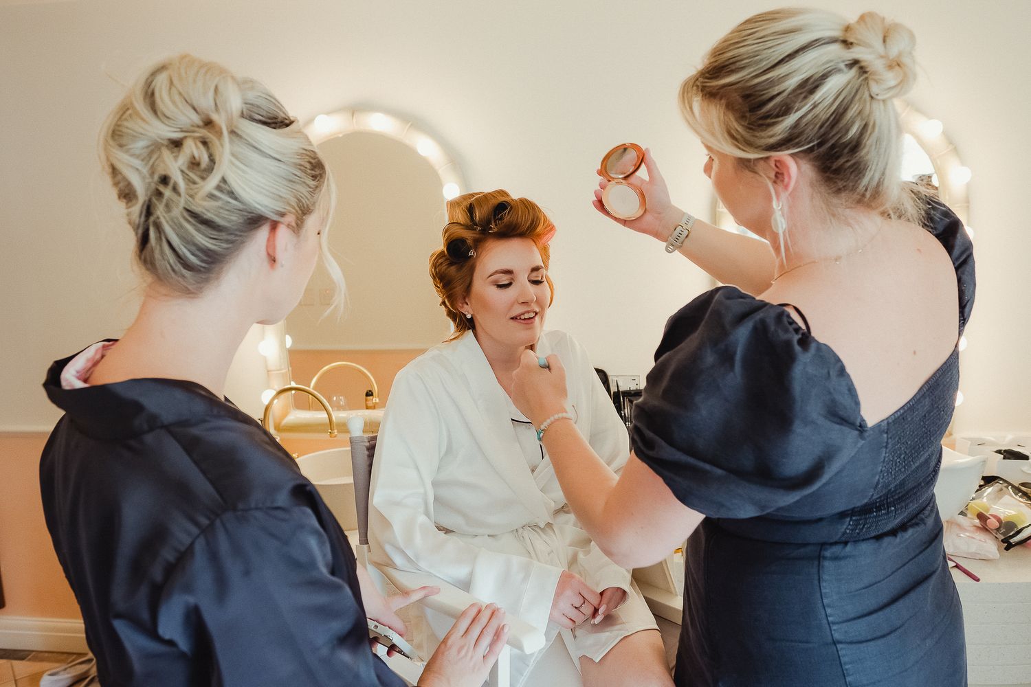 Bride at LIMEKILN getting ready in a bridal suite with makeup being applied while wearing robes - LIMEKILN Wedding Photography