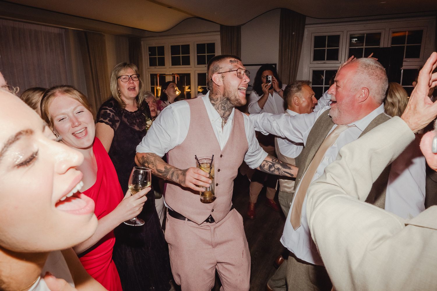 People dancing and celebrating together at a lively indoor party or reception.