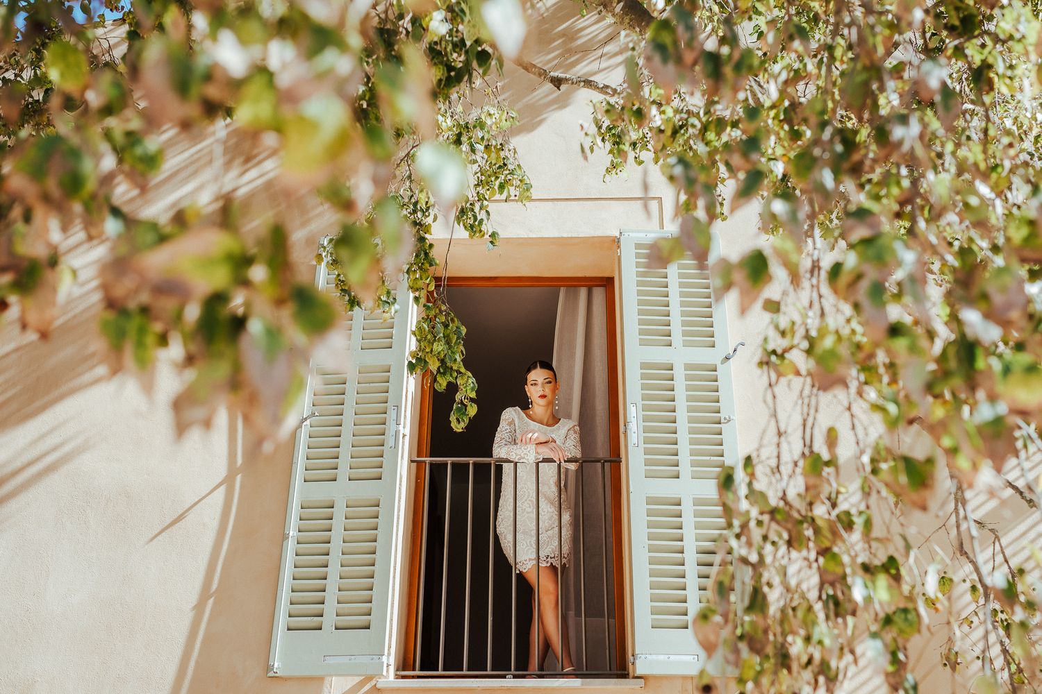 A series of five architectural photos showing white shuttered windows and blooming spring tree branches against a beige wall.