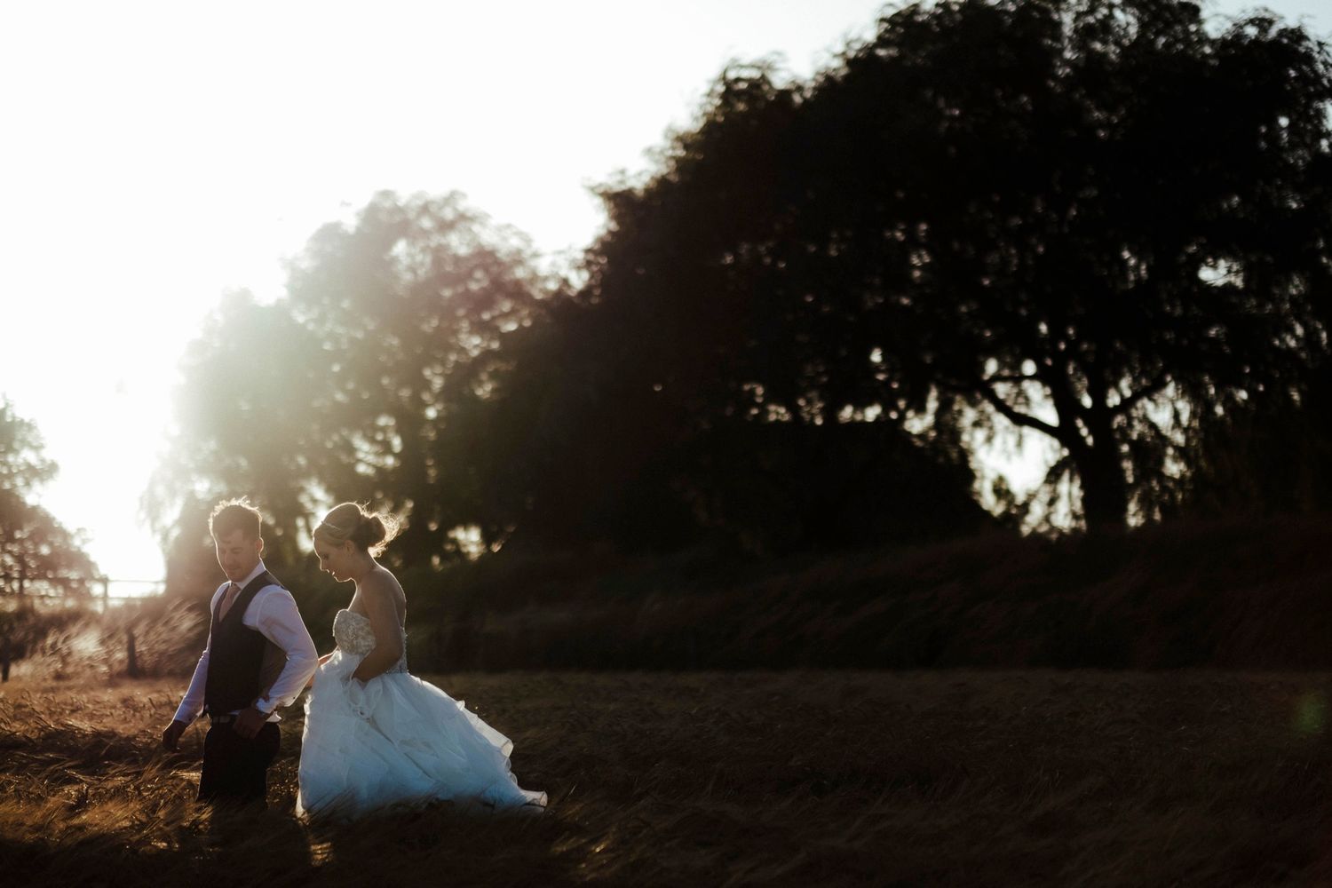 A couple shares an intimate moment in golden sunset light during their wedding photoshoot.