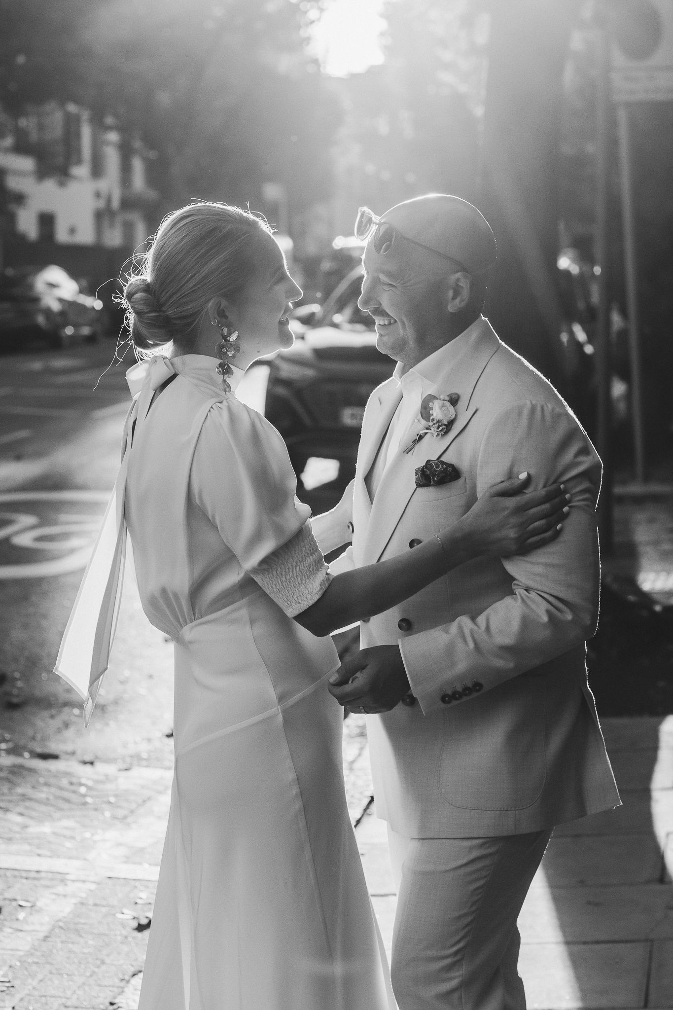 A couple in light-colored formal attire dances together in a candid sequence of black and white photographs.
