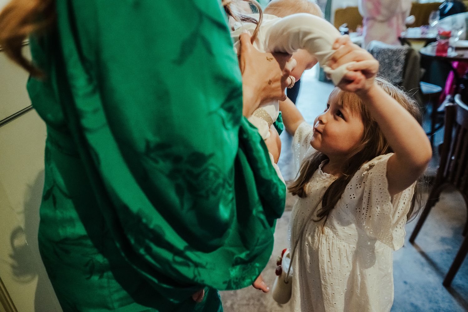 A healthcare provider in green administers eye drops to a young patient during a medical examination.
