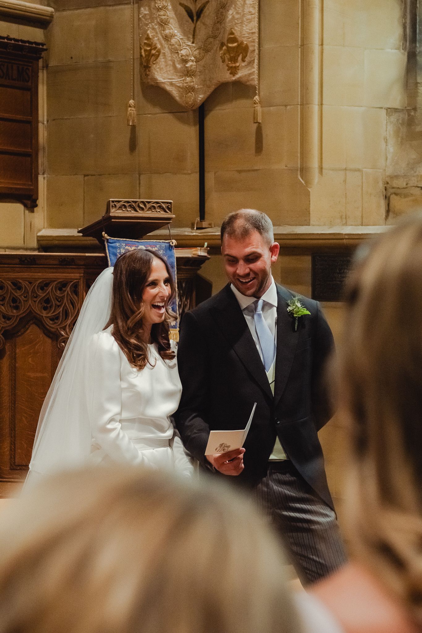 A joyful wedding ceremony moment captured inside a historic church with ornate stone architecture and wooden details.