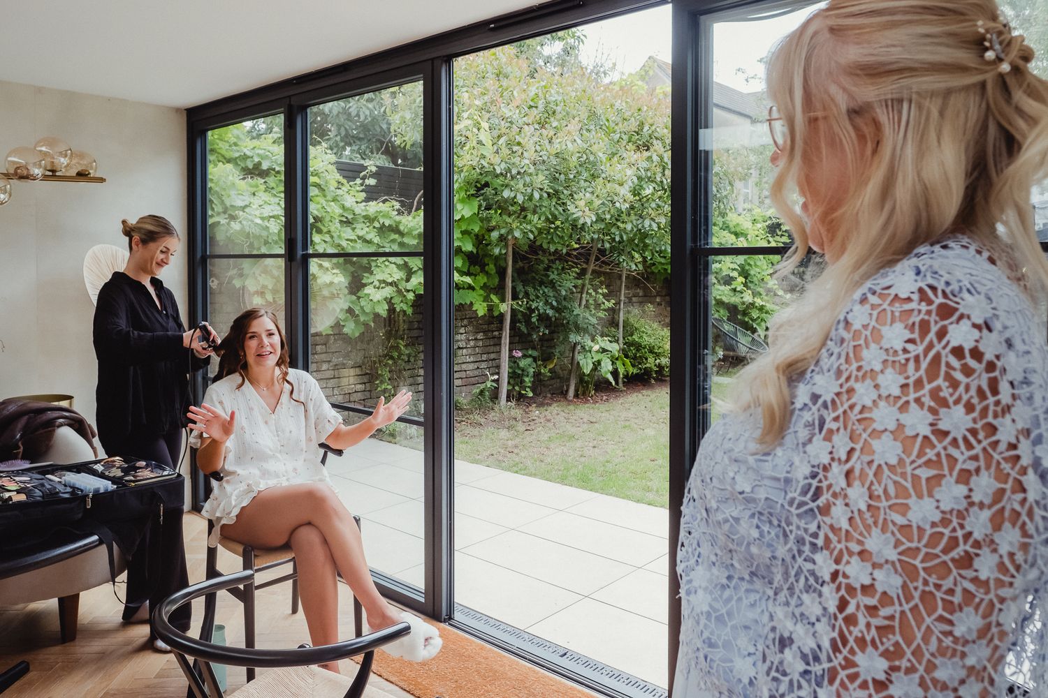 A series of candid getting-ready moments captured through glass windows showing preparations in a bright, modern space.