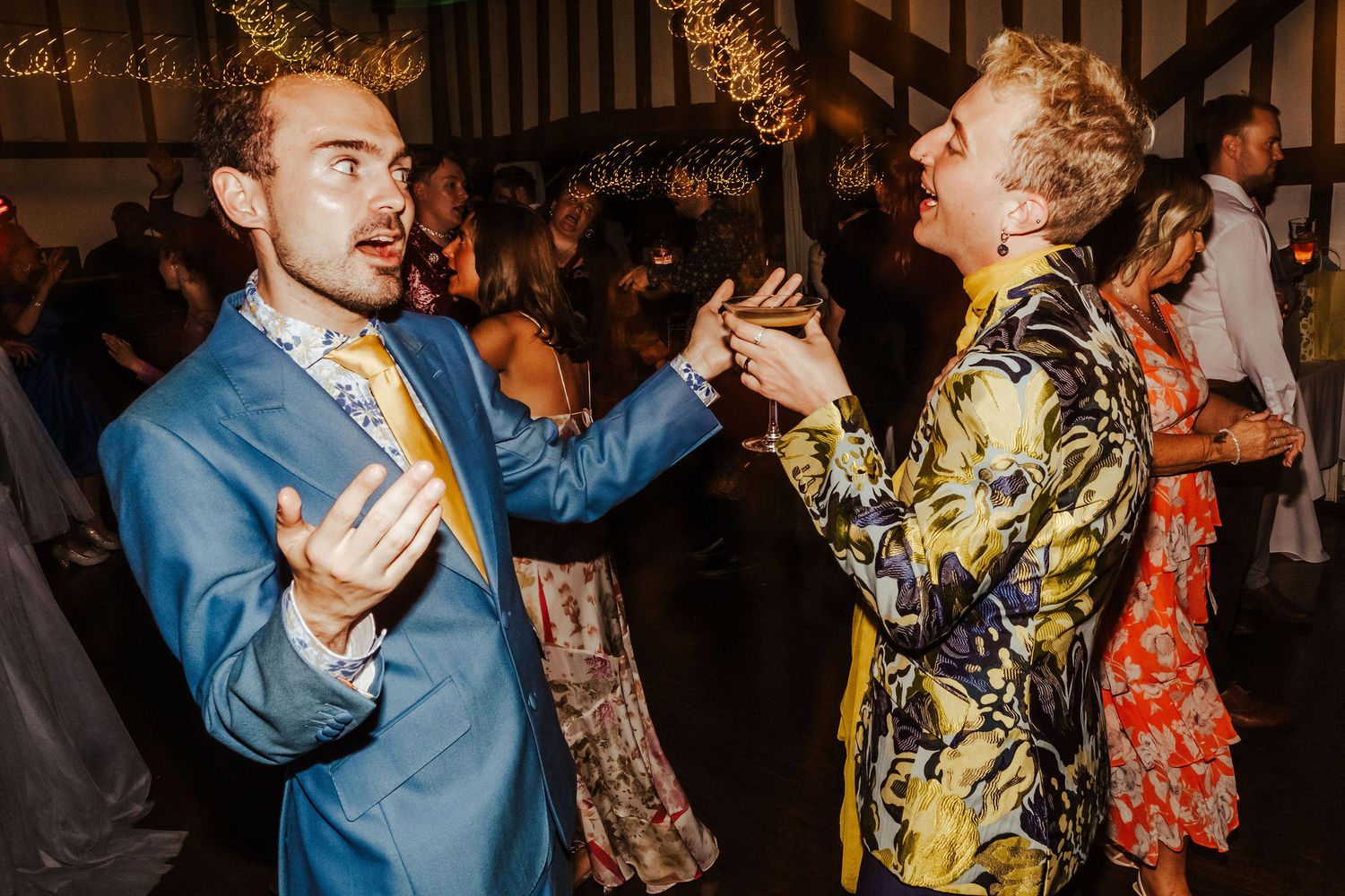 People dancing and celebrating at a lively party with colorful outfits and energetic movements.