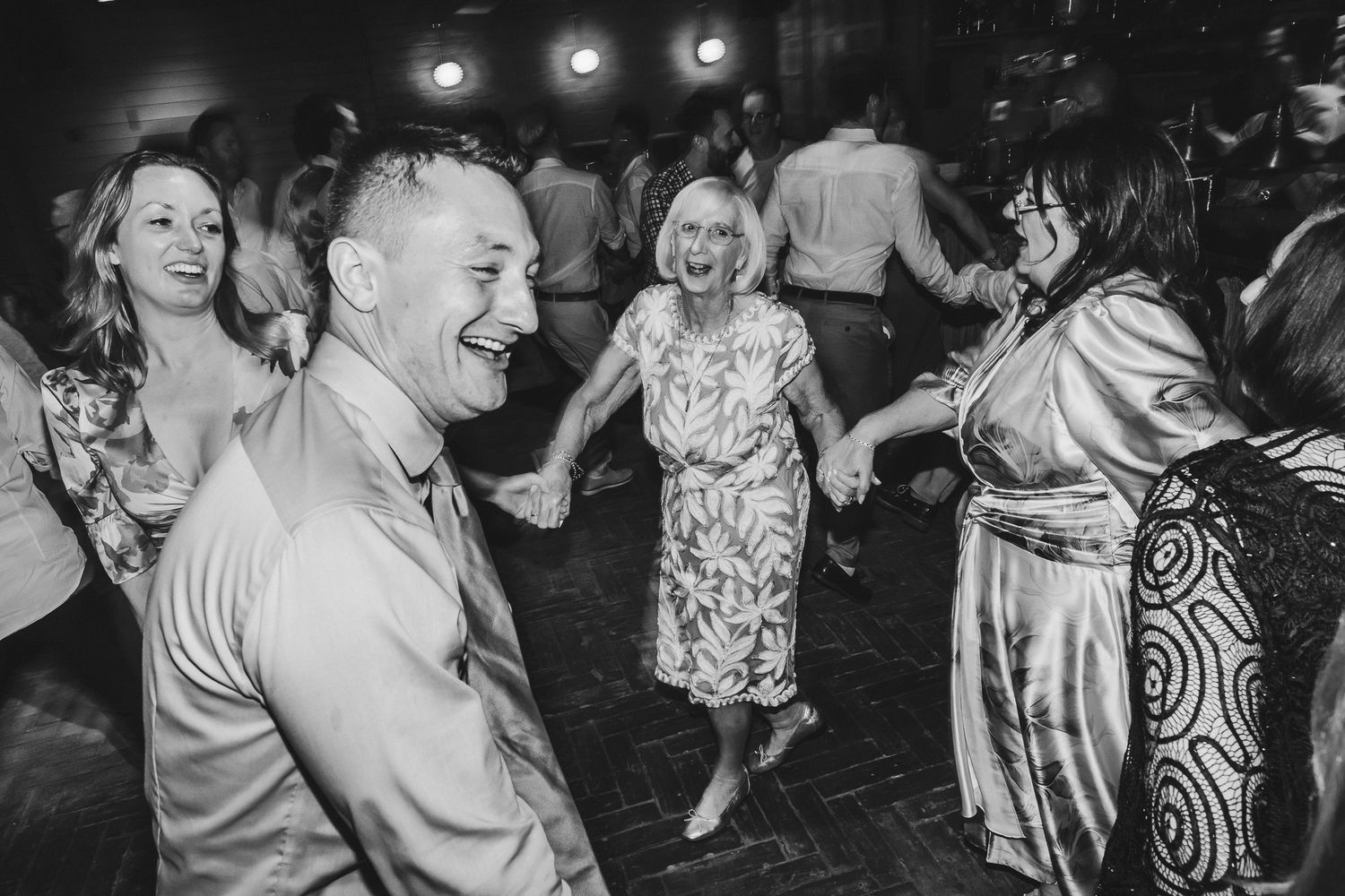 Black and white photos show people dancing and celebrating at a lively party or reception.