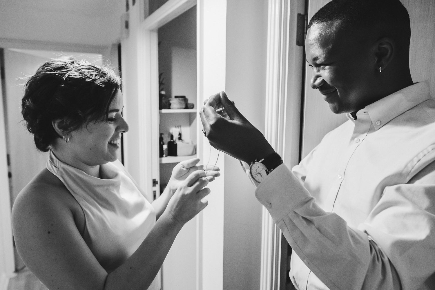 A black and white photo sequence shows someone applying makeup in a bathroom mirror.