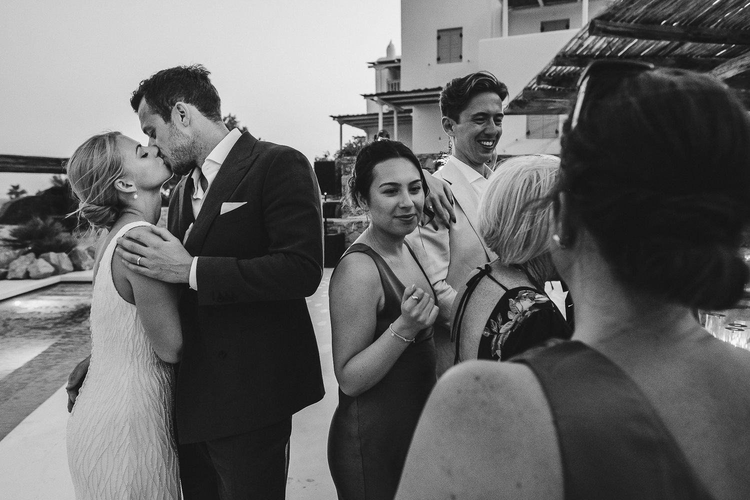 A collage of black and white wedding photos showing romantic moments between newlyweds outdoors.