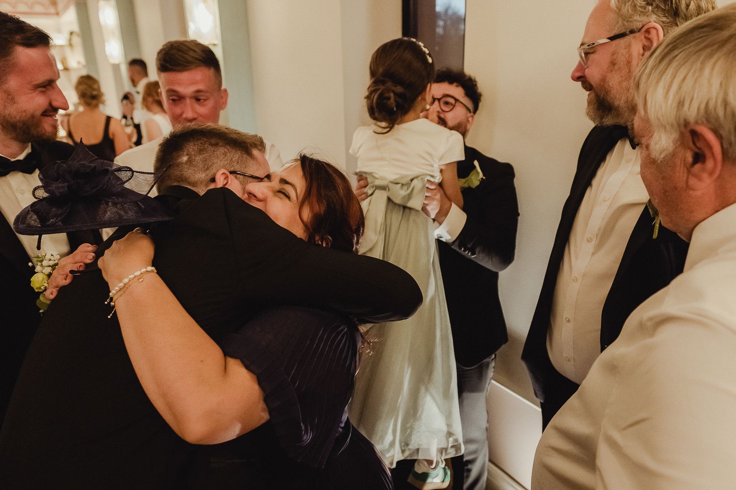 Wedding guests dance and celebrate together on the dance floor at an indoor reception.