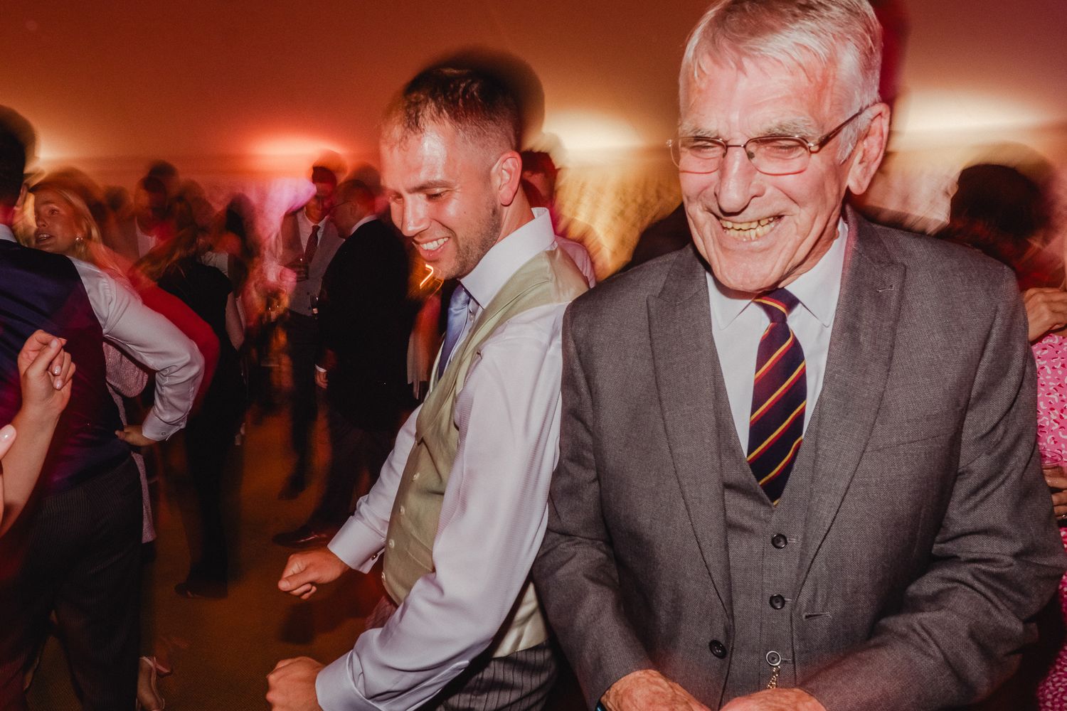 A group of people dancing together at an evening party with warm lighting and festive atmosphere.
