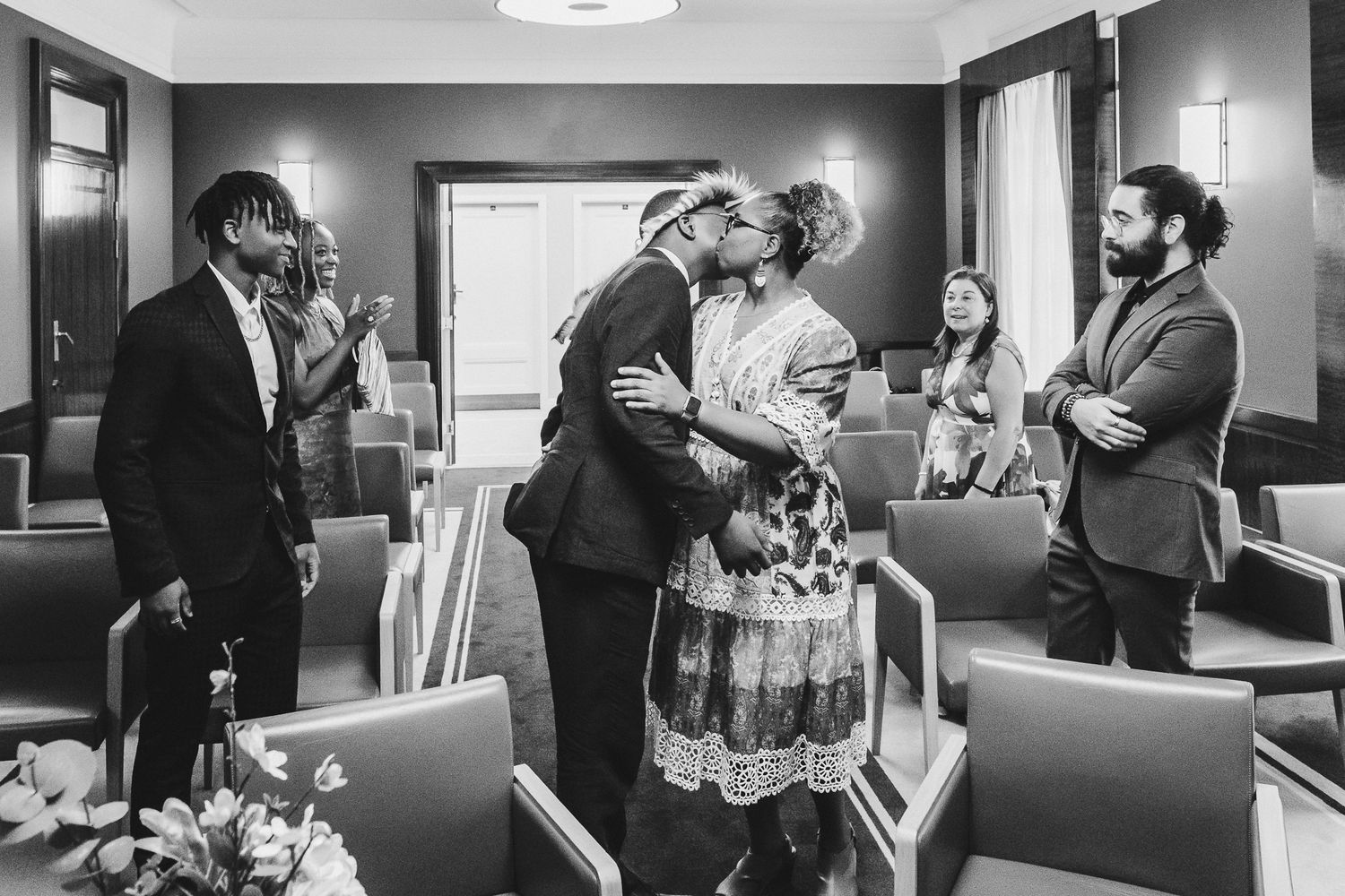 Black and white photo series showing candid moments of guests mingling and interacting at a formal event.