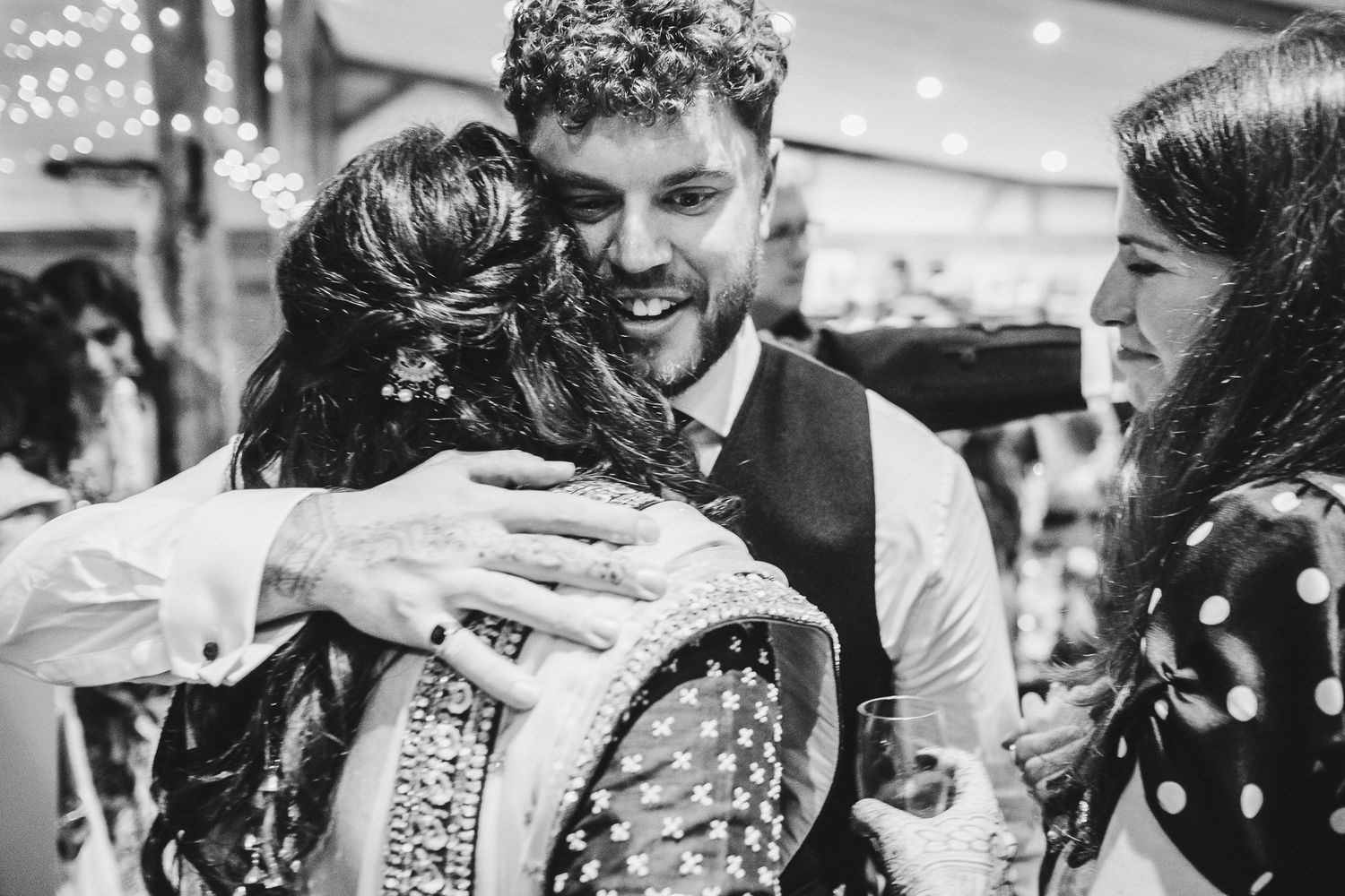 Wedding guests share warm embraces during a celebration.