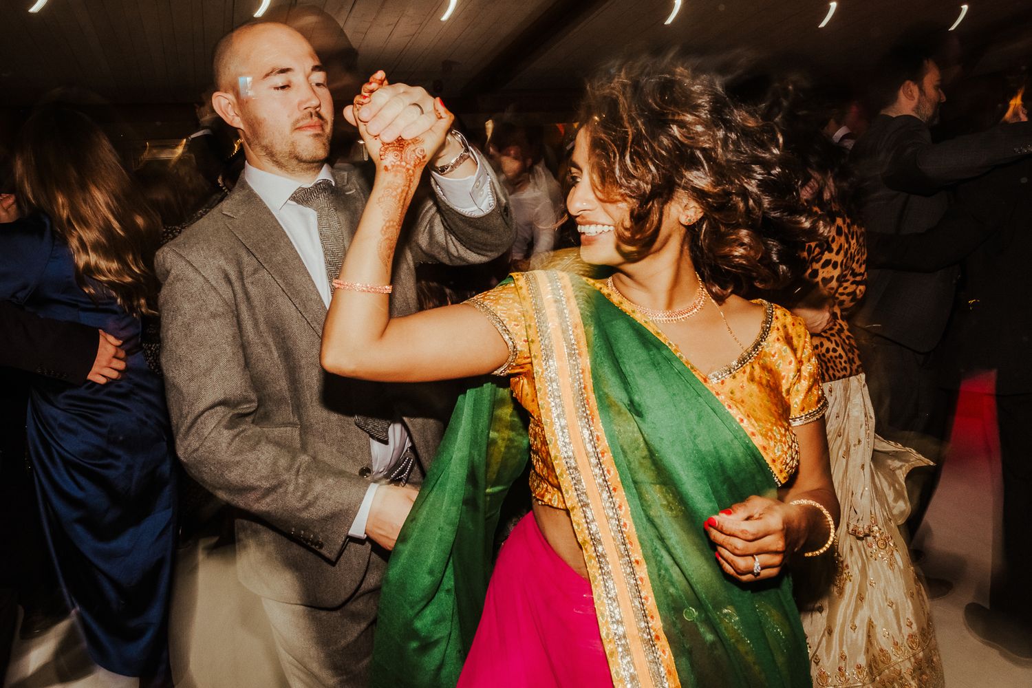 Couple dancing in traditional Indian and Western fusion wedding attire.