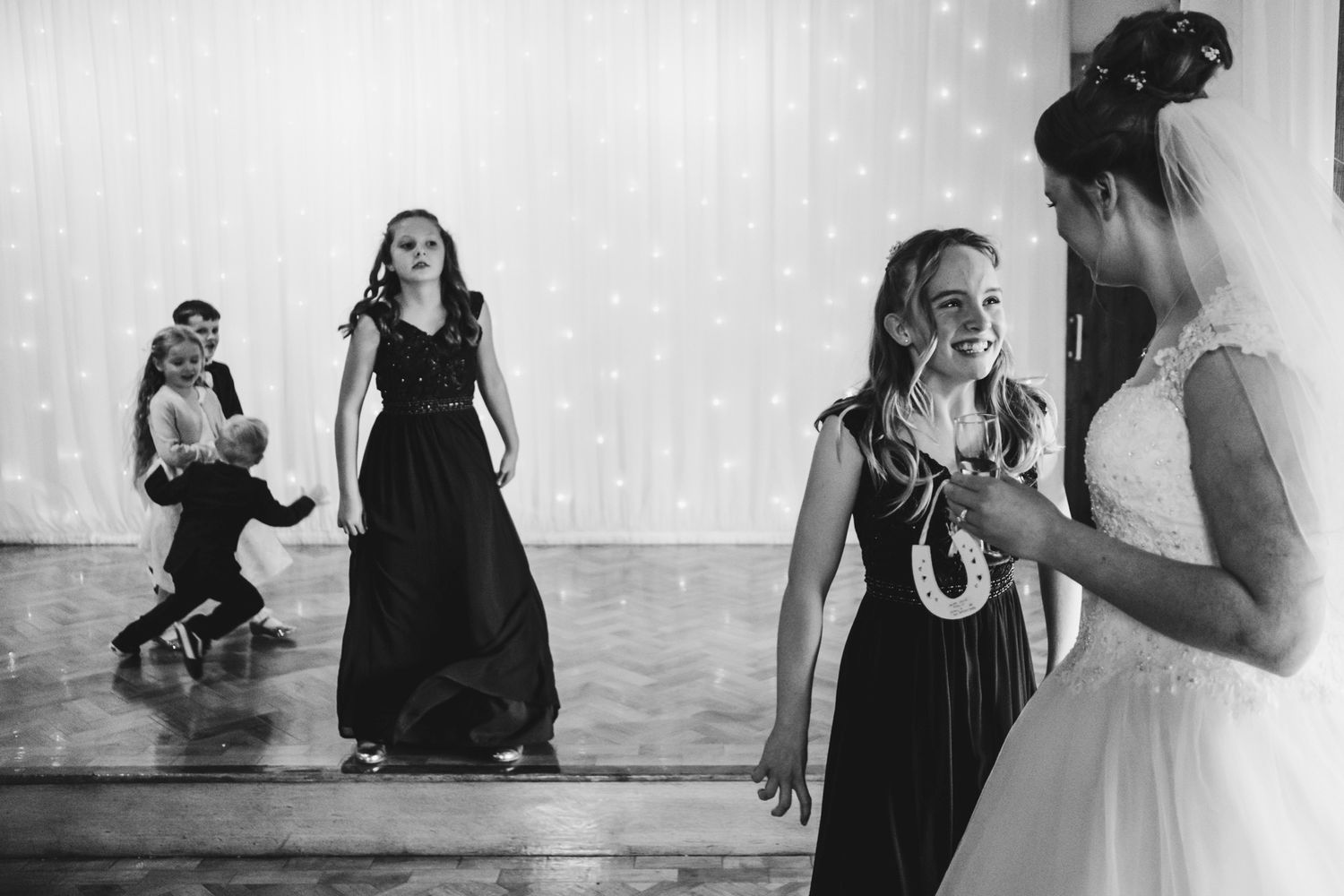 Wedding guests dancing and celebrating in black dresses during the reception.