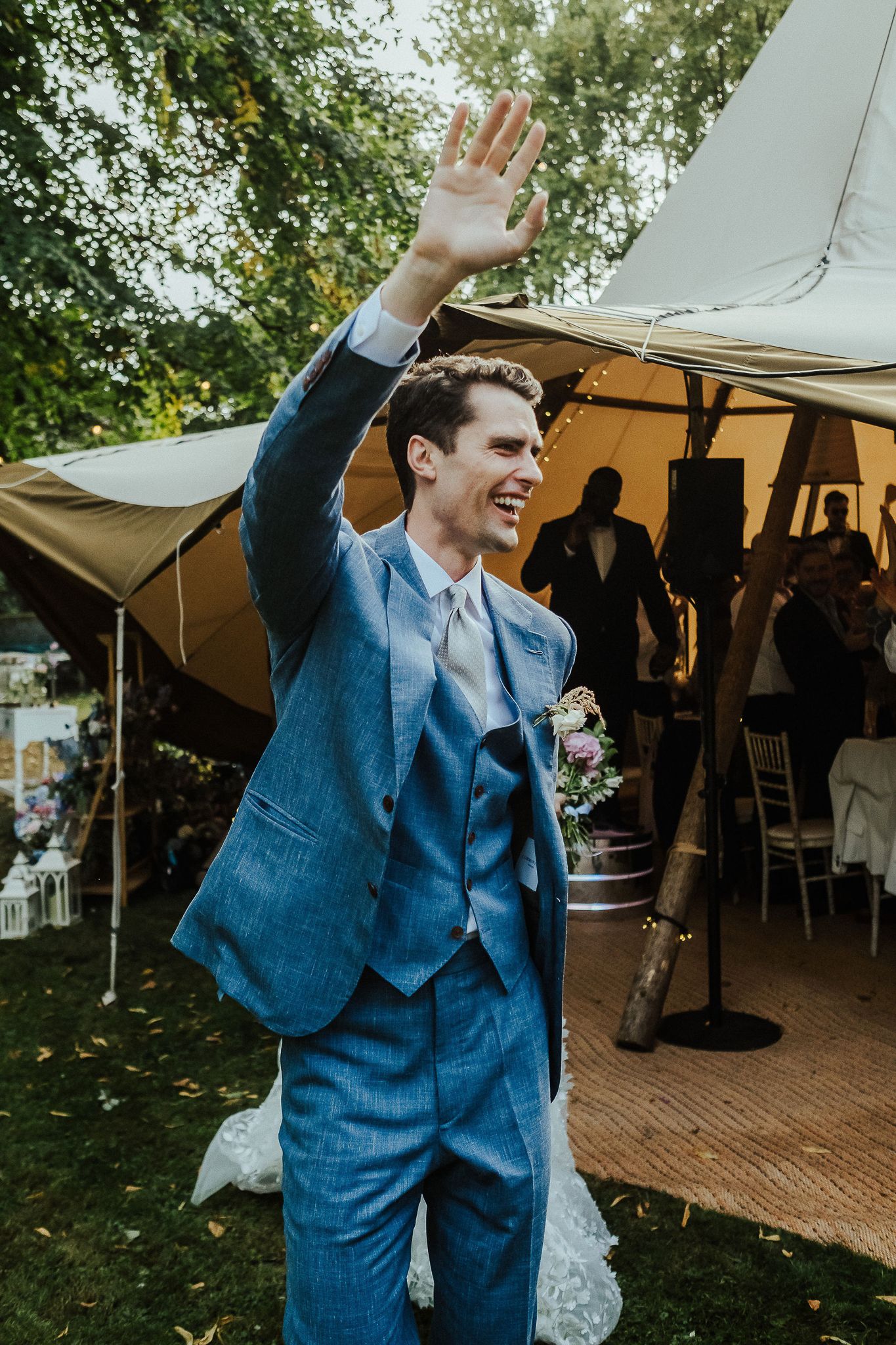 Joyful dance moments at an outdoor tented wedding reception with natural backdrop.