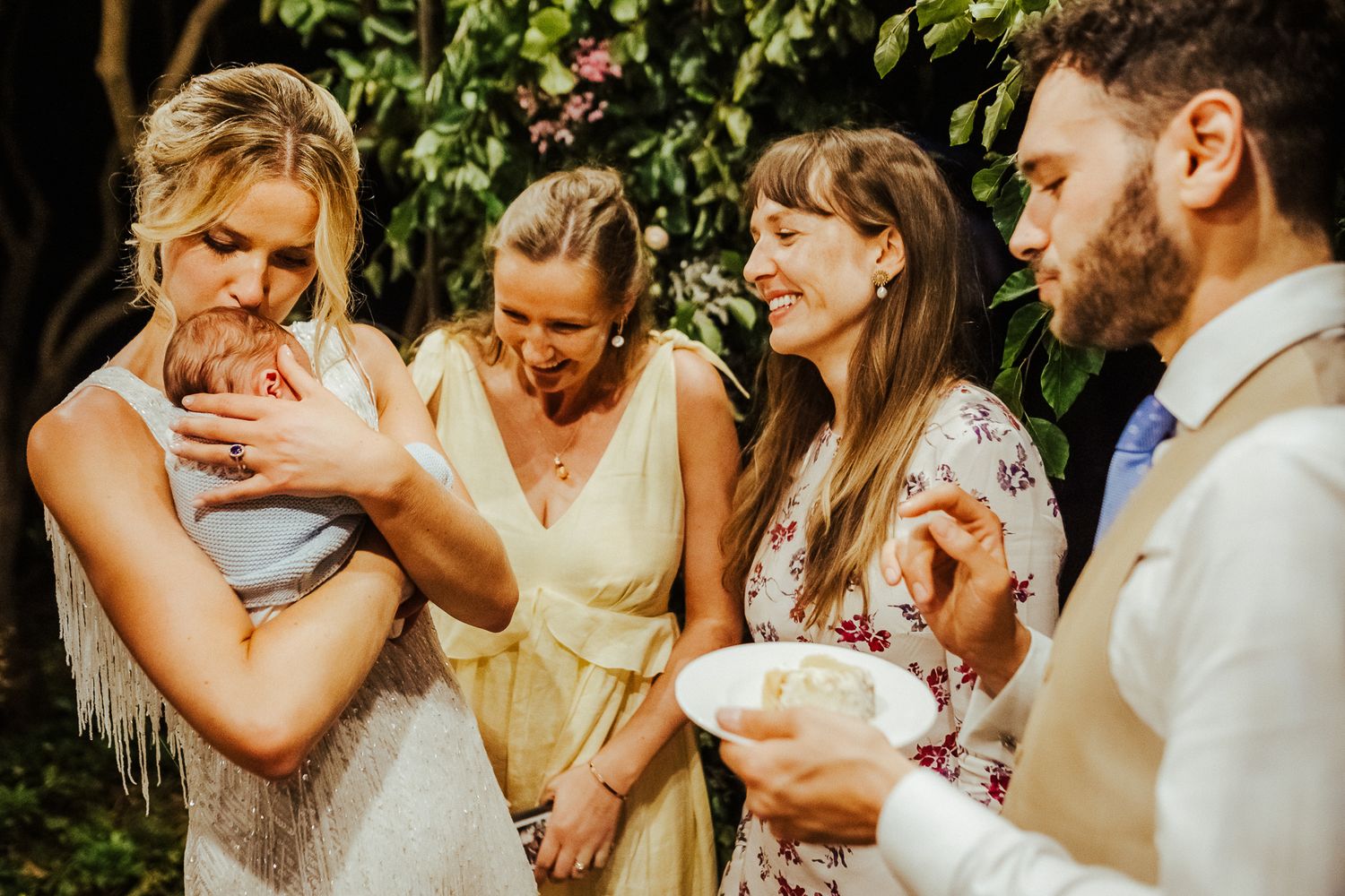 Wedding guests enjoying desserts and treats in an outdoor garden setting.