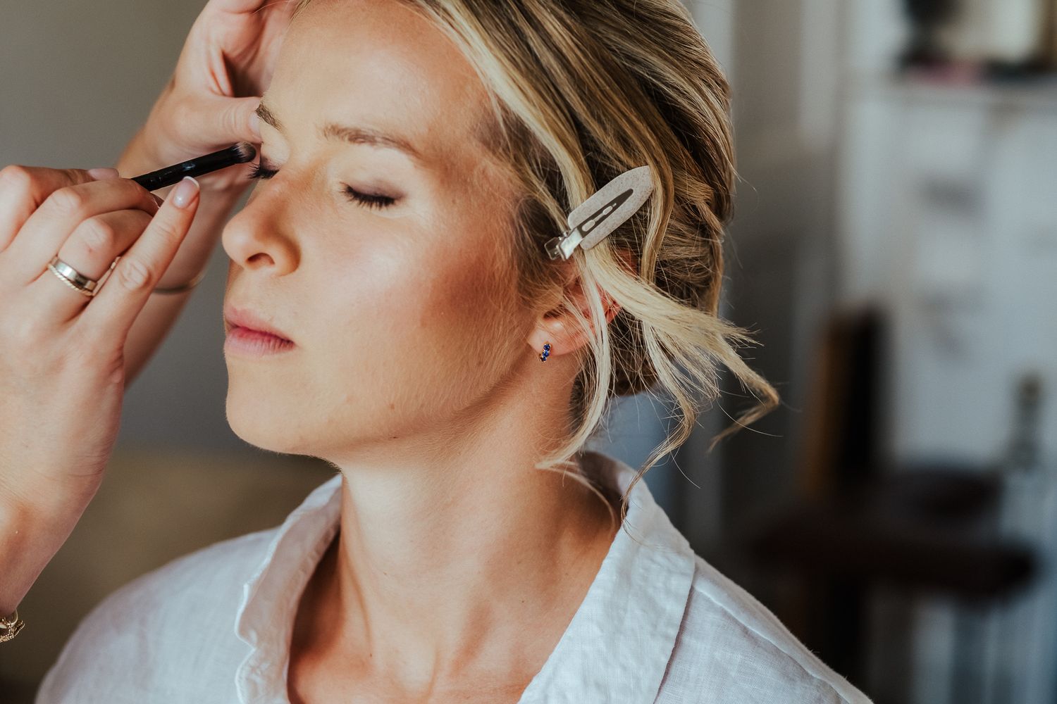 Close-up of bridal makeup application with soft natural lighting.