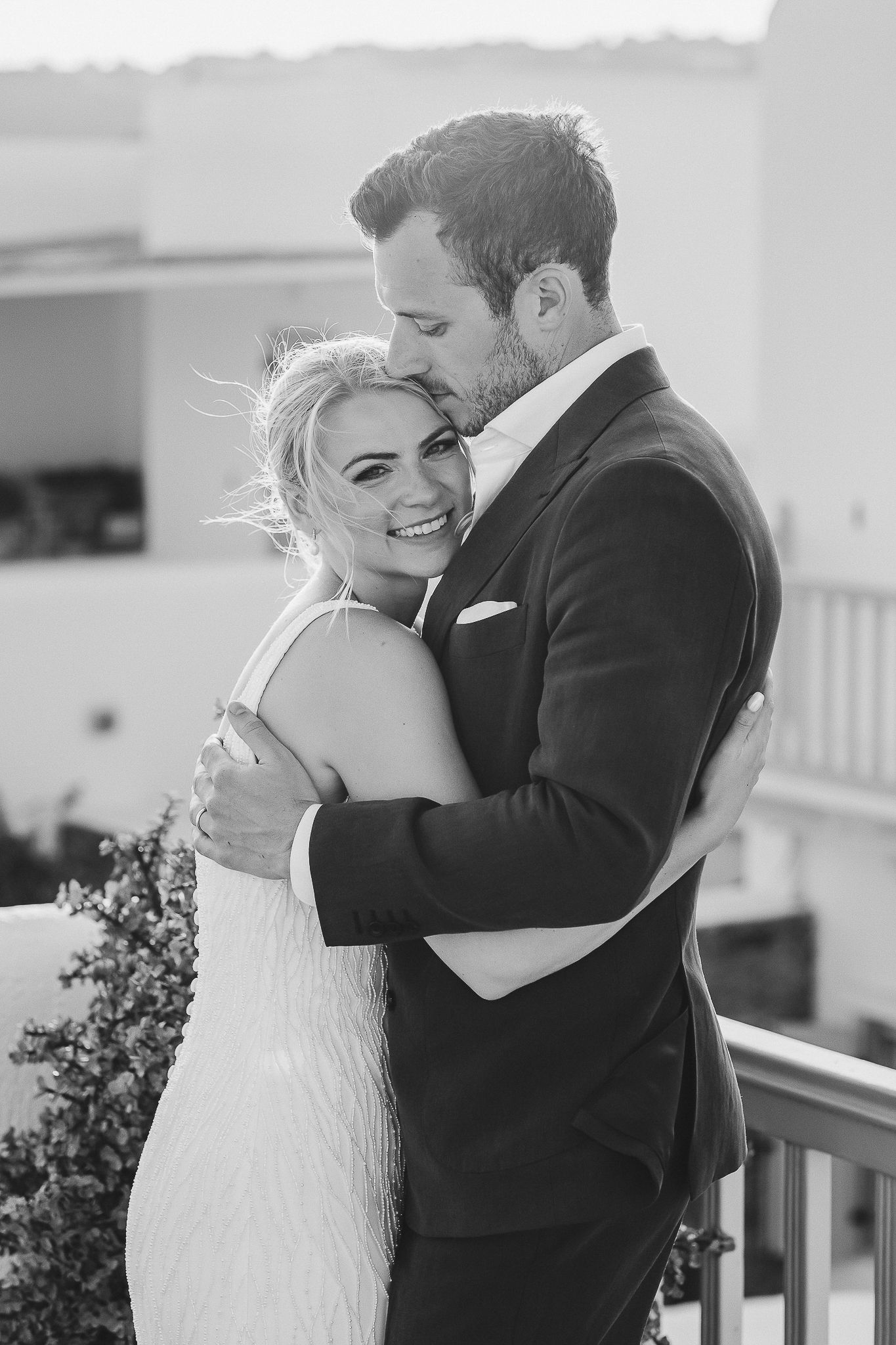 A romantic black and white photo series of newlyweds sharing intimate embraces on their wedding day.