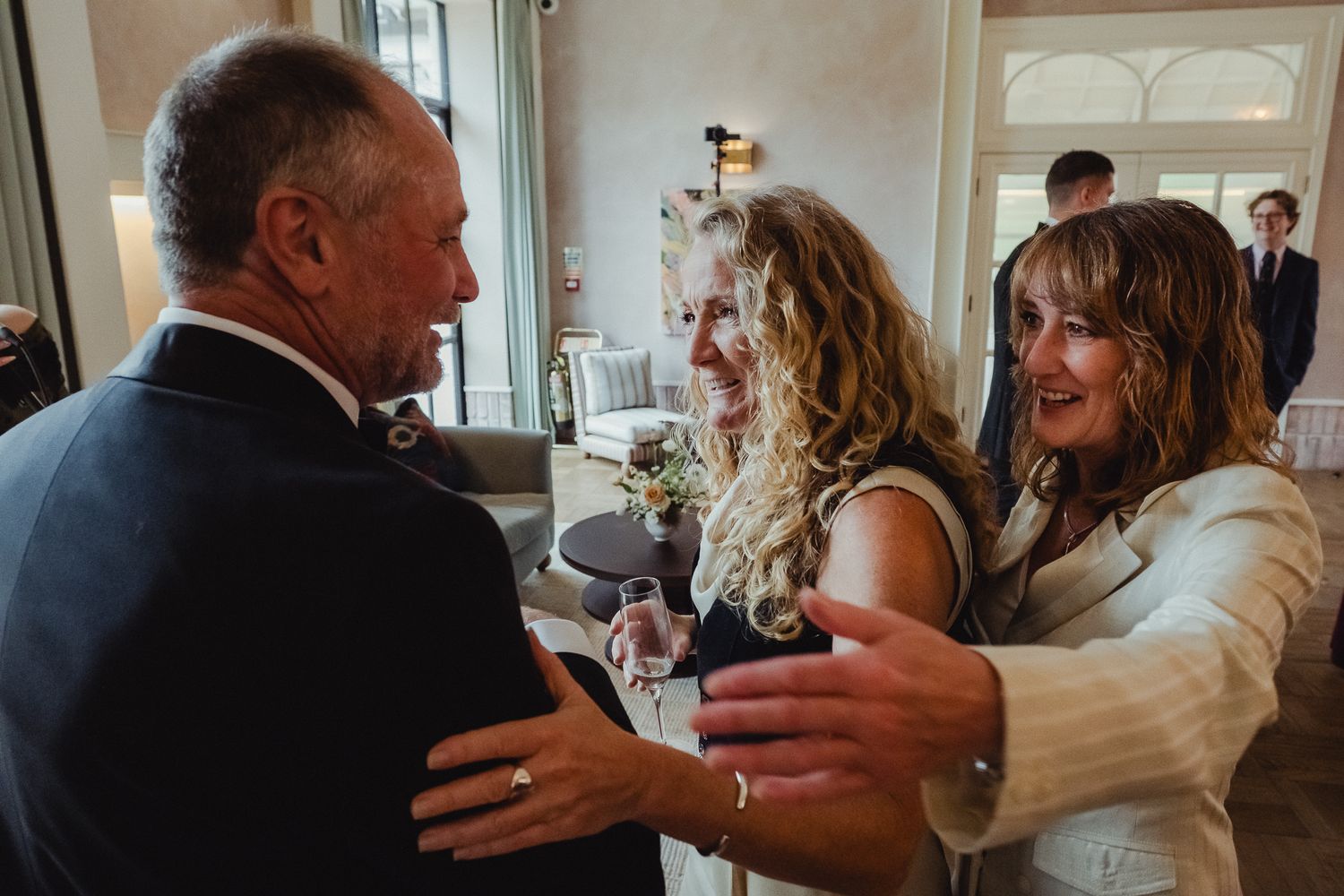 A joyful moment captured at a wedding reception as guests embrace and celebrate together.