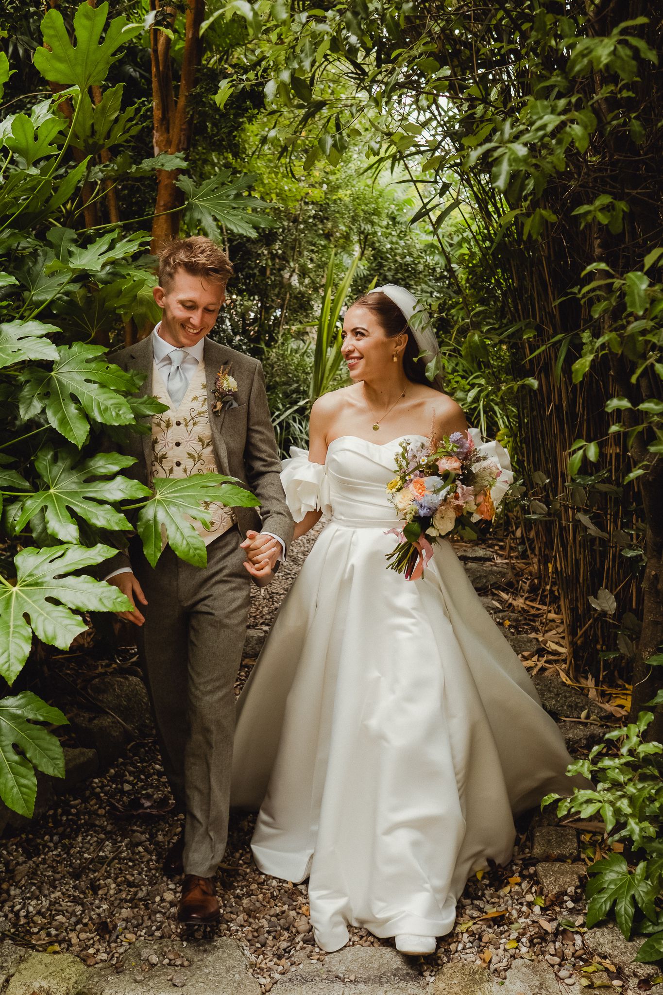 Couple shares intimate moments in a lush garden setting during their wedding photoshoot.