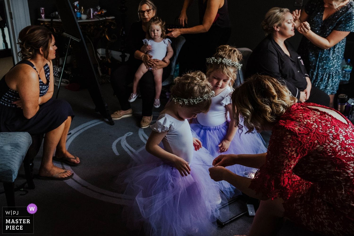 Wedding reception dance floor scene with guests in formal attire and purple lighting effects.