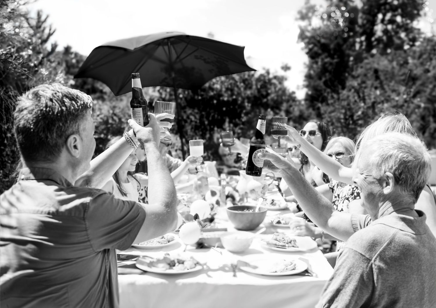 Black and white images of guests enjoying food and drinks at an outdoor celebration.