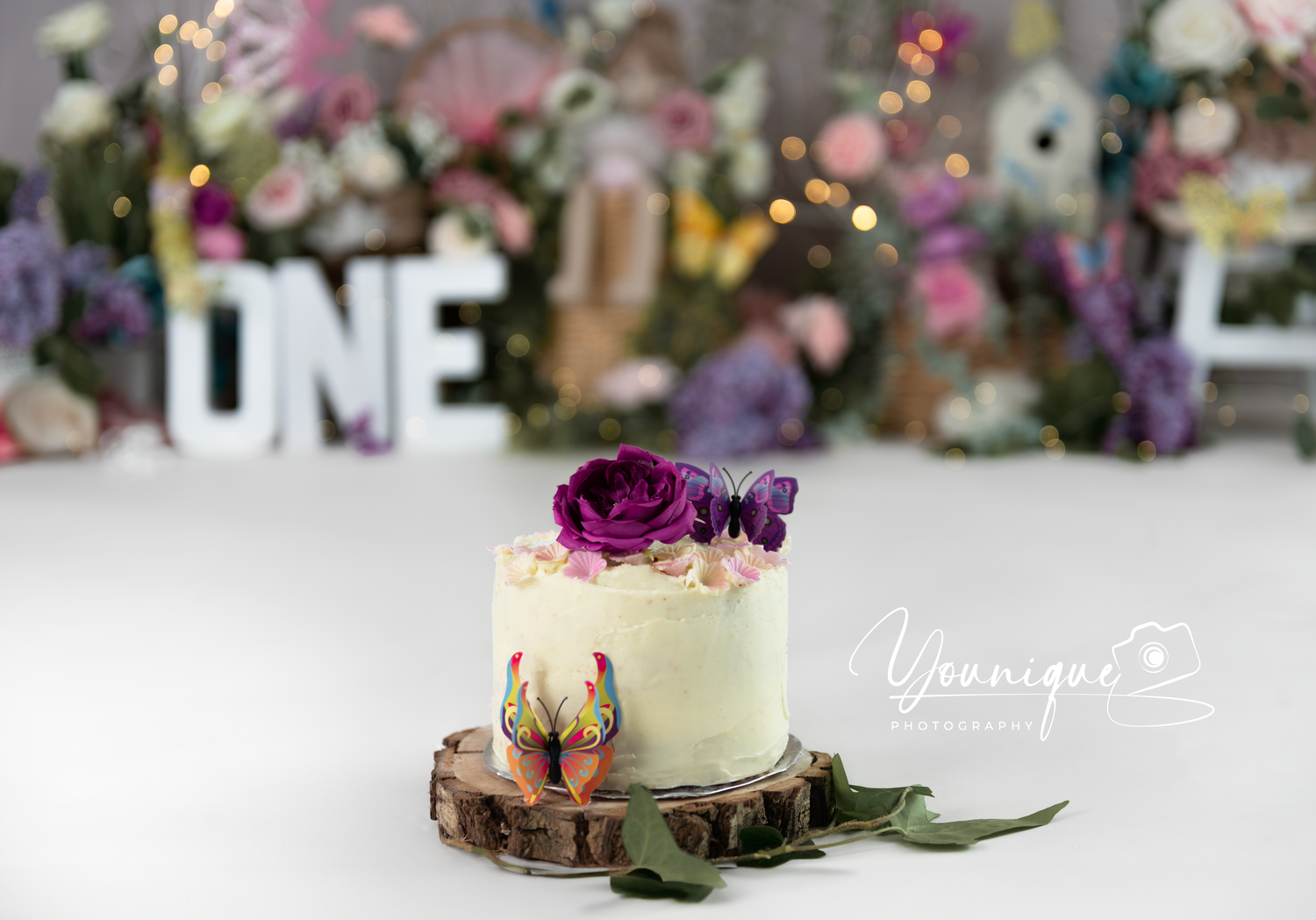 A beautifully styled wedding dessert table with delicate floral arrangements and white candles creates an elegant display.