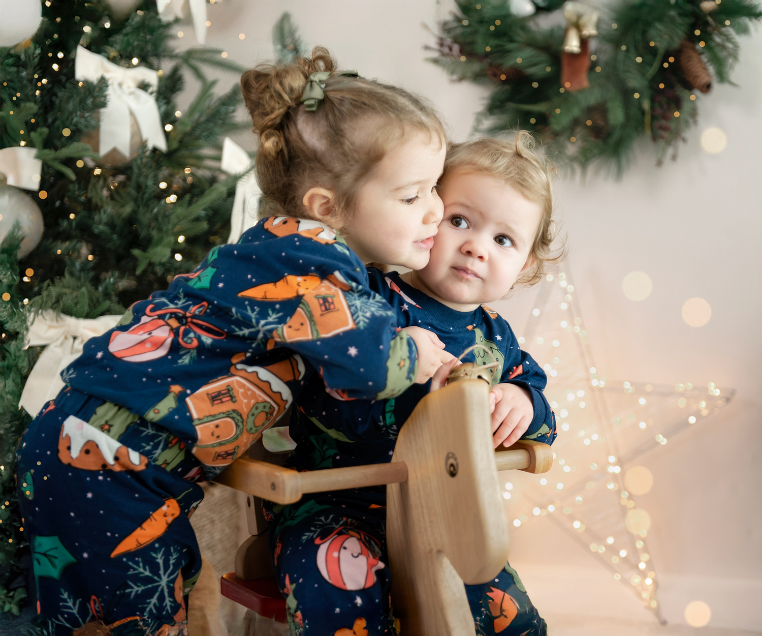 Sweet candid holiday photos of a parent and child sharing tender moments in front of a Christmas tree with twinkling lights.