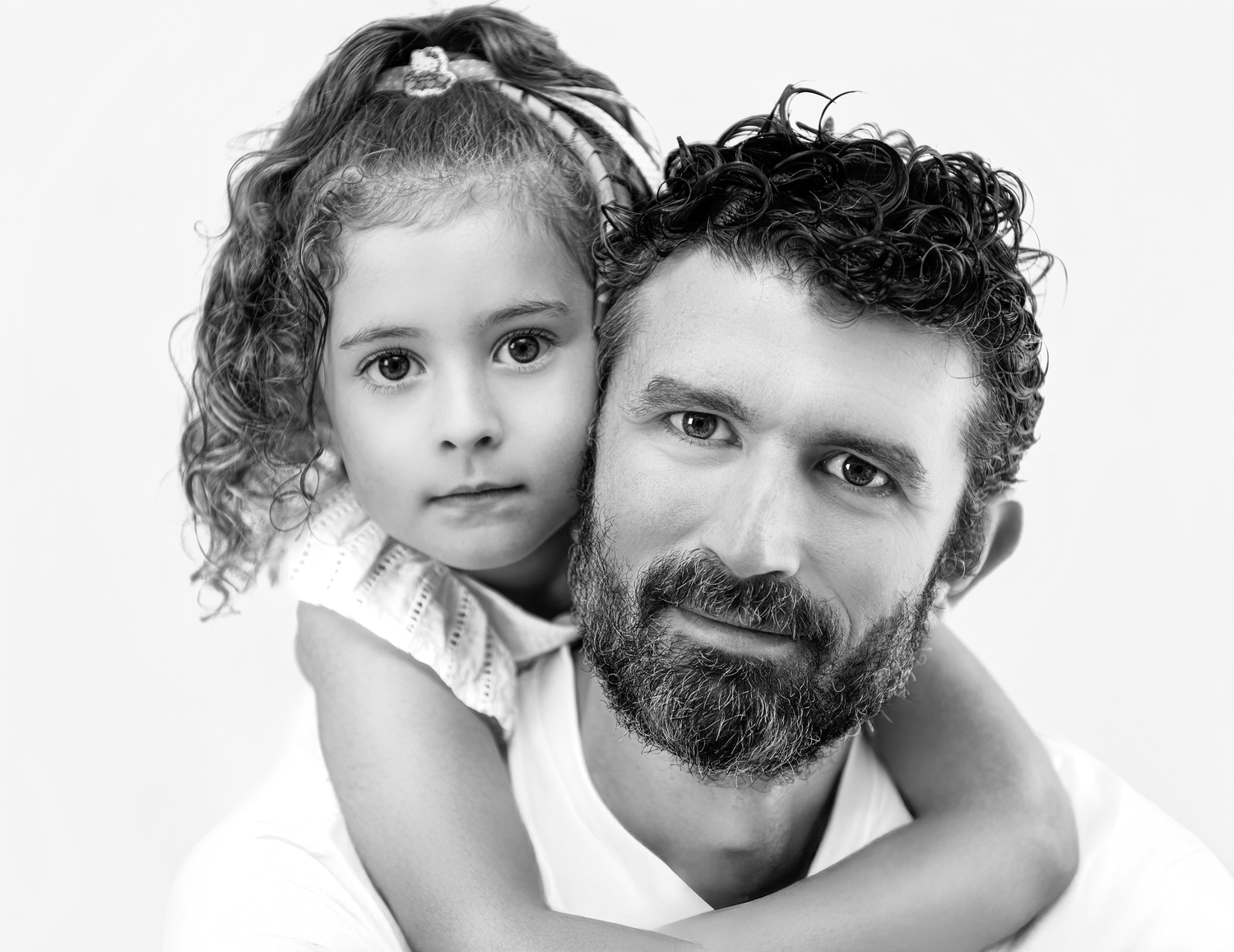 Black and white portrait collage showing three candid moments between a bearded adult and child against white background.