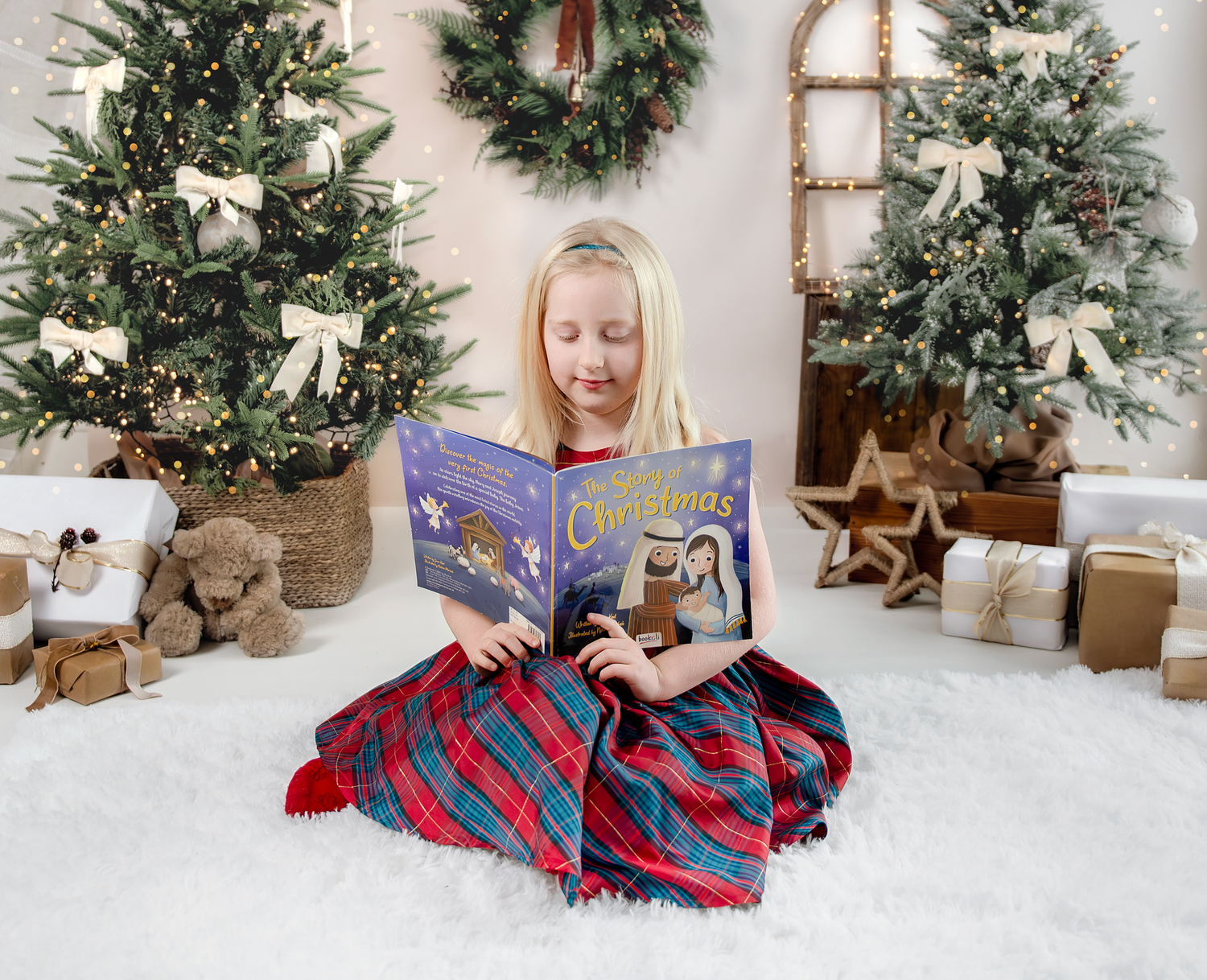 A cozy Christmas scene with a decorated evergreen tree, plaid blanket, wrapped gifts, and festive greenery wreaths.