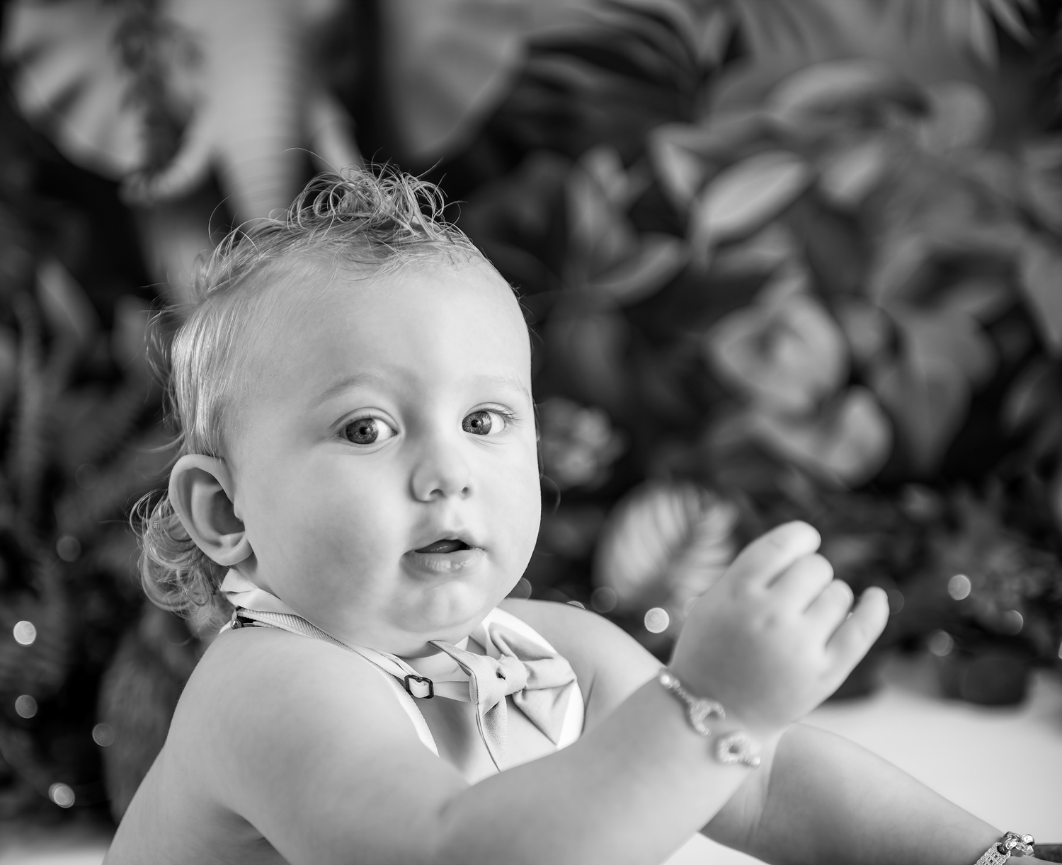 Black and white close-up photo of a baby looking upward with an expressive face and curious expression.