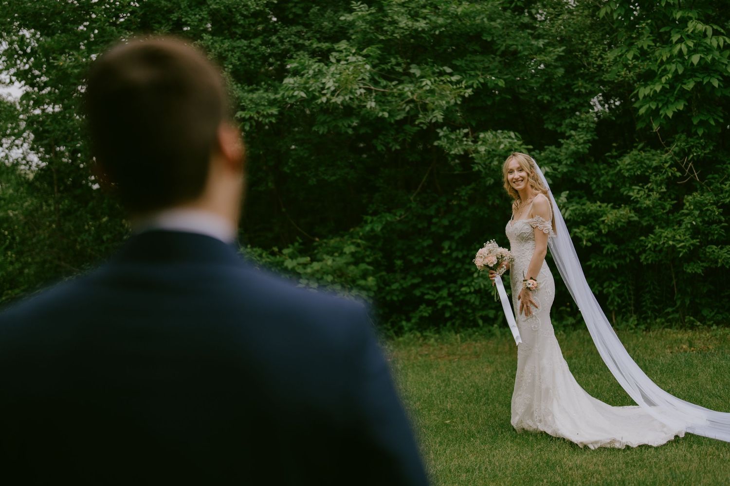 Bride looking over shoulder at groom with soft smile
