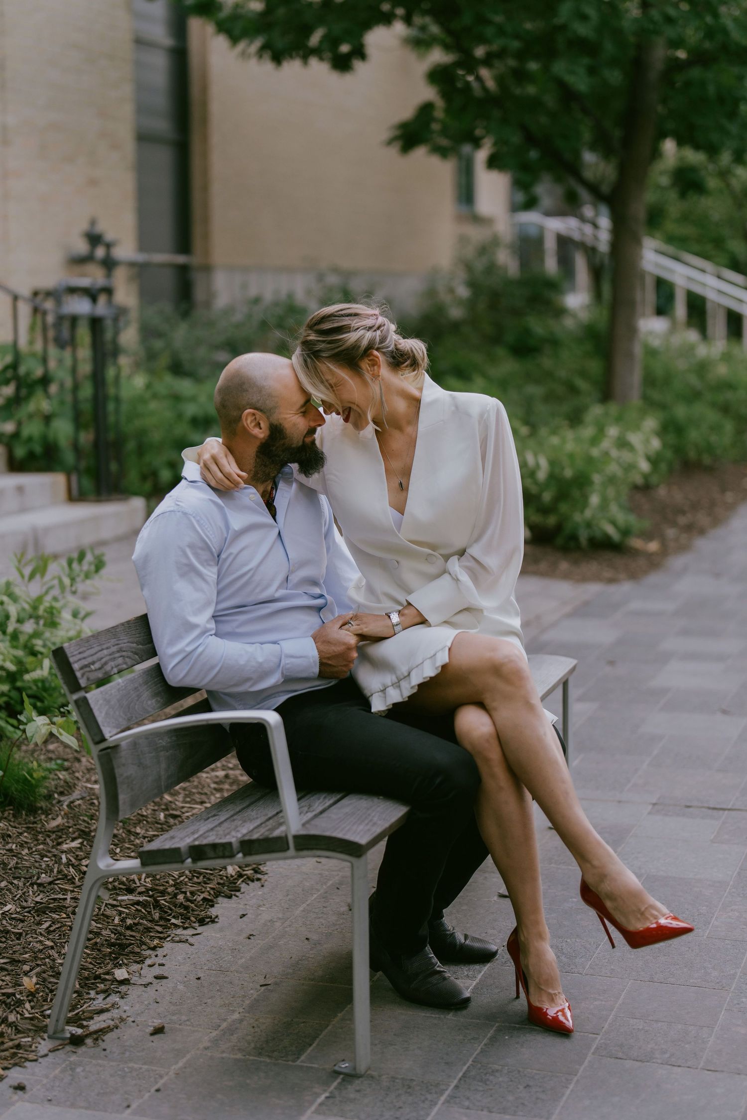 Sweet candid moment of couple sharing a close conversation on city bench
