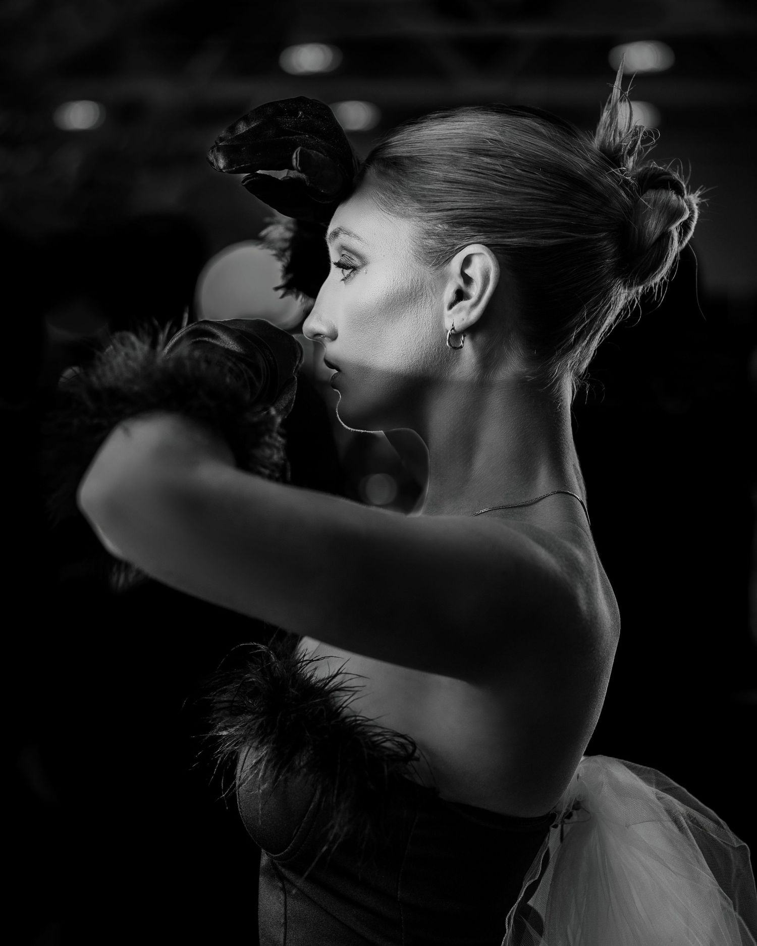 Black and white close-up of bride adjusting earring before wedding