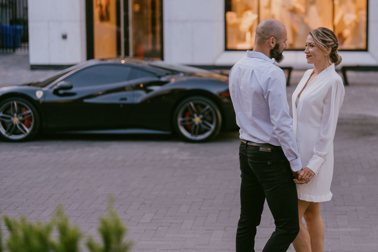 Chic urban wedding session with a stylish couple standing in front of a luxury black sports car in Toront, Ontario