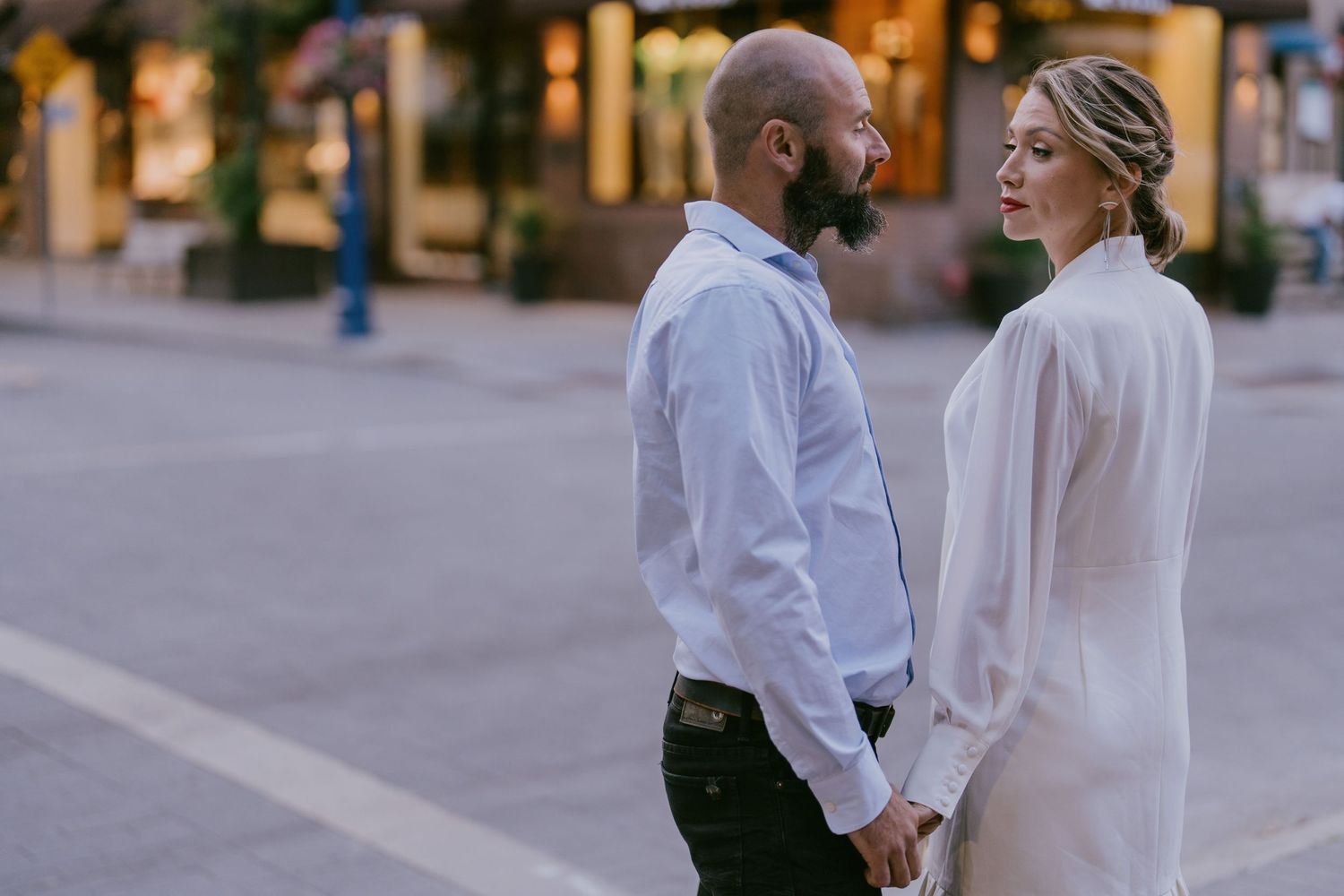 Chic couple sharing a moment at a downtown crosswalk during golden hour